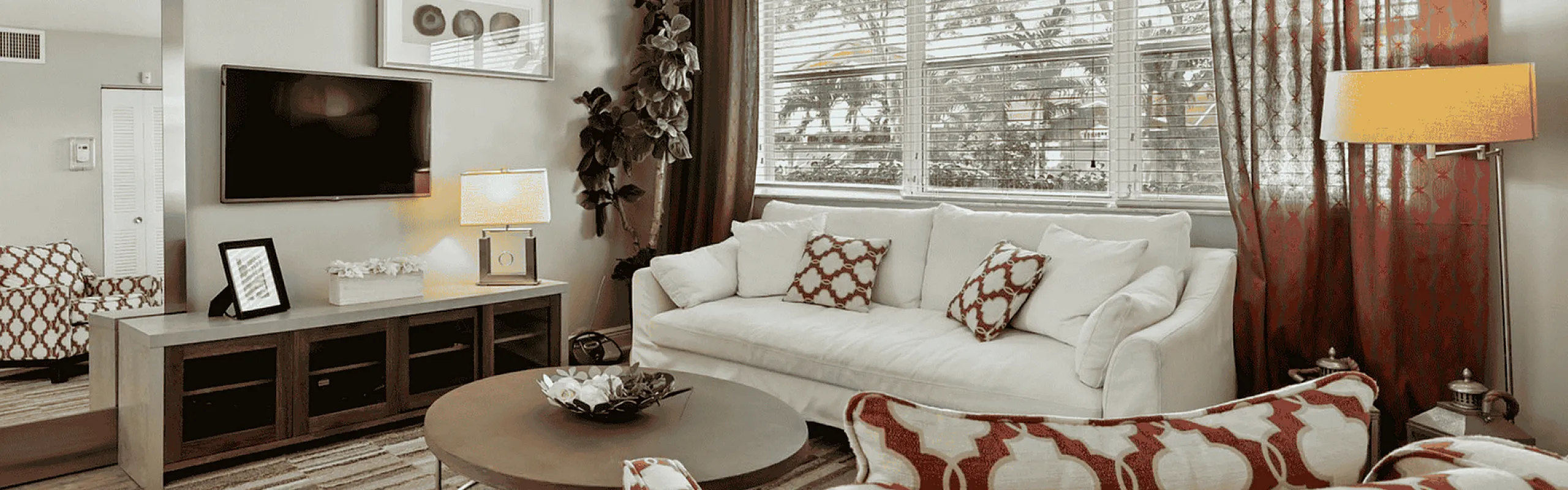 Elegant living room with plush seating, modern decor, and large windows offering natural light and picturesque views.