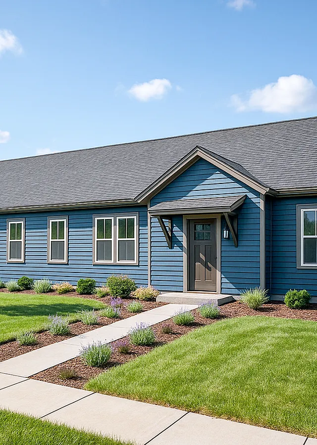 Charming blue ranch-style home with manicured lawn, inviting walkway, and picturesque setting.