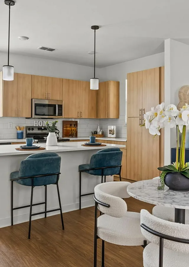 Contemporary kitchen with sleek white countertops, modern appliances, and inviting dining area accented by stylish decor.