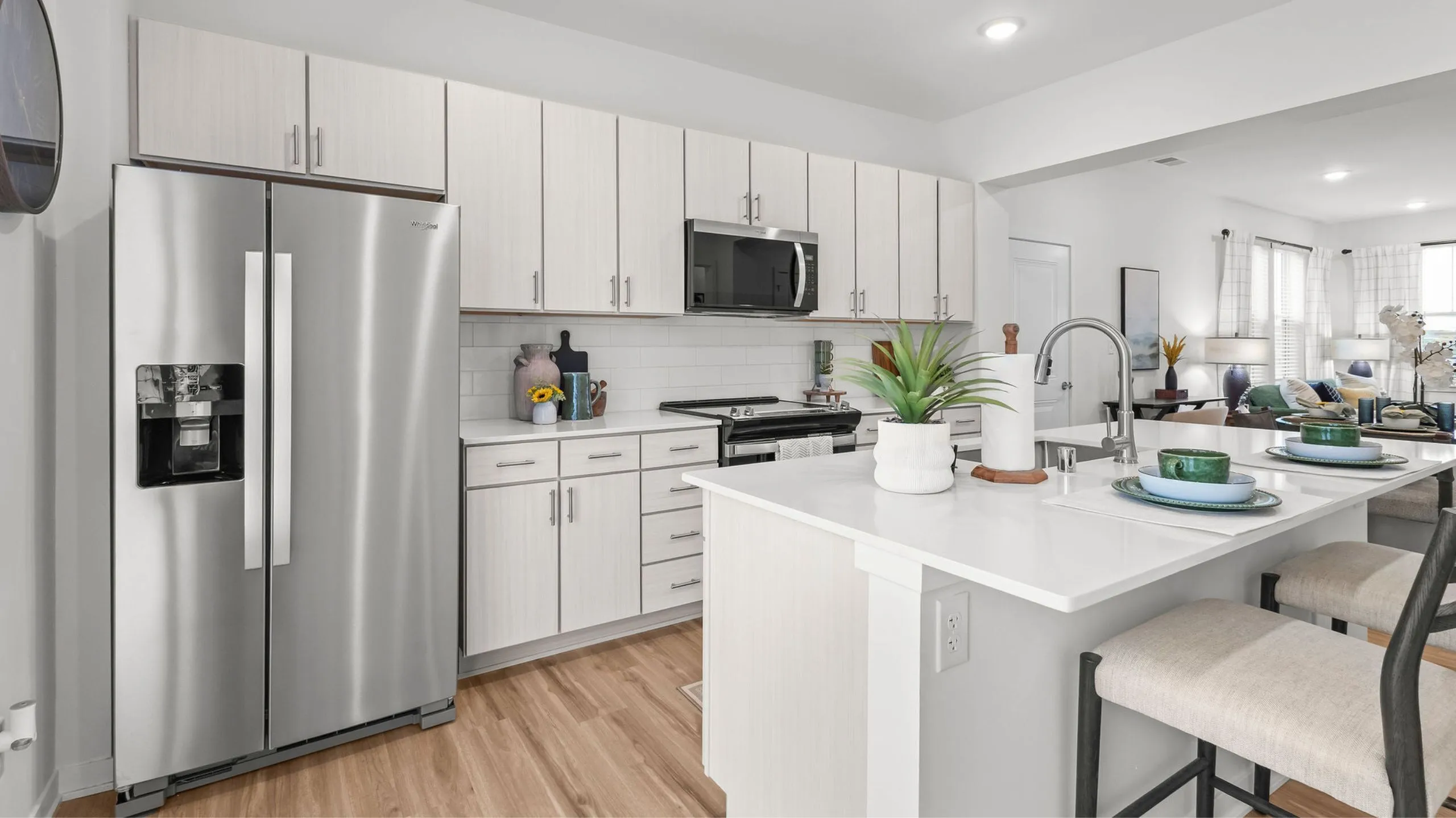 Bright, modern kitchen with sleek stainless steel appliances, elegant white cabinets, and a cozy breakfast bar perfect for casual dining.