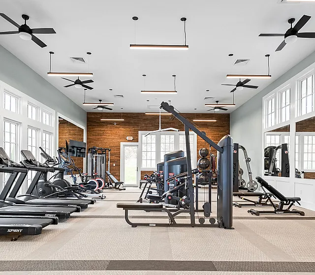 Spacious and modern fitness center featuring state-of-the-art equipment and large windows for natural light.