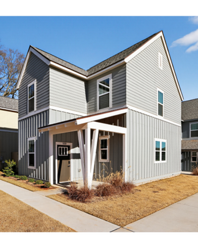 Charming modern cottage-style home with elegant grey siding, inviting covered porch, and bright windows.