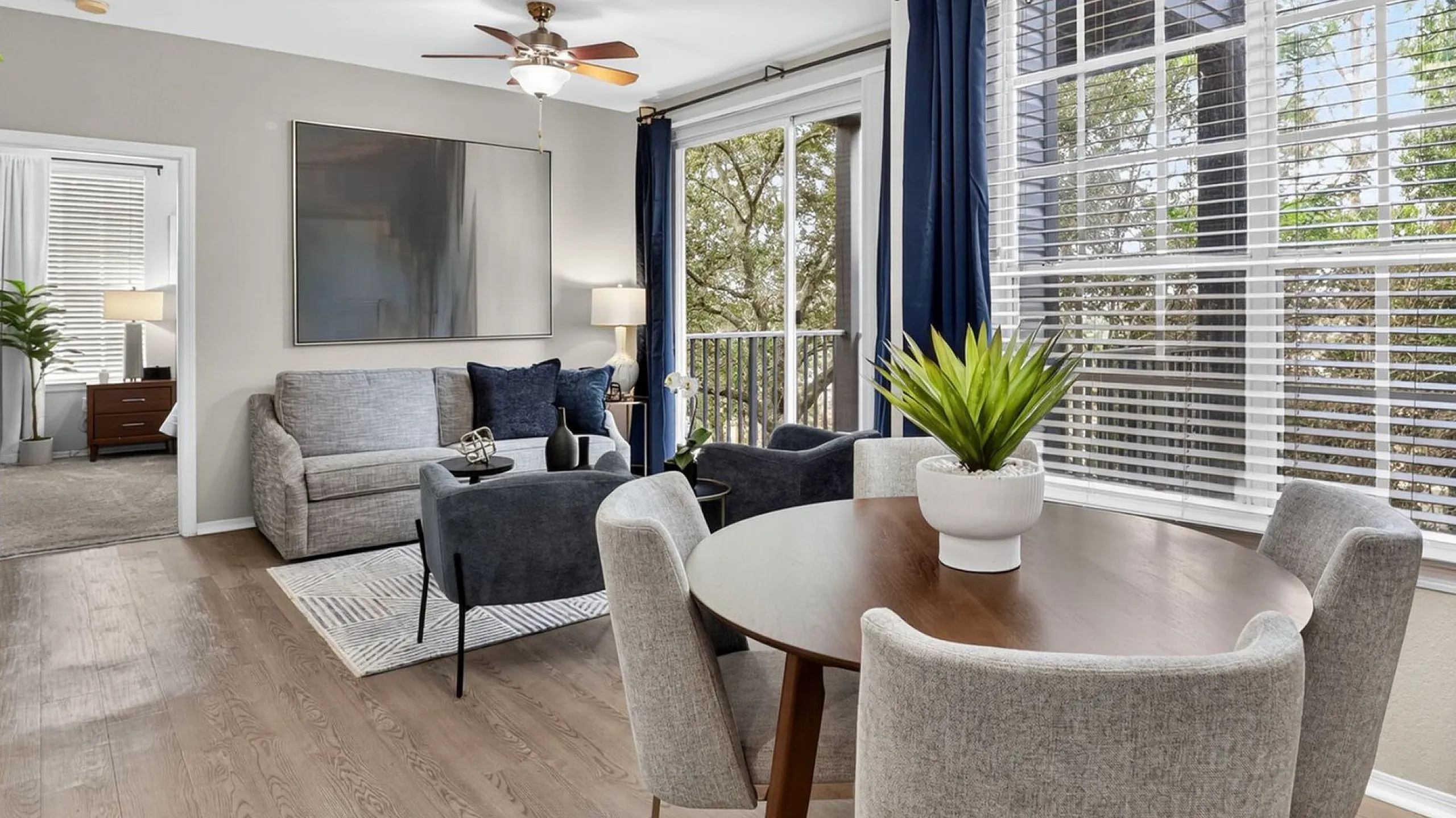 Bright, elegant living and dining area with large windows, modern furnishings, and chic decor.