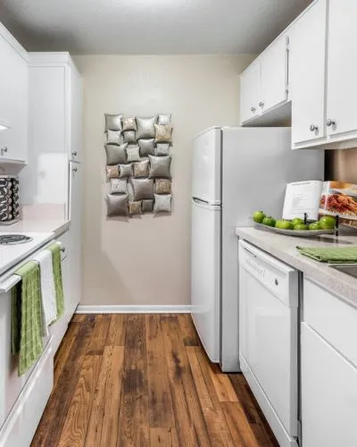 Charming kitchen with sleek white cabinets, modern appliances, and elegant hardwood flooring, perfect for culinary creativity.