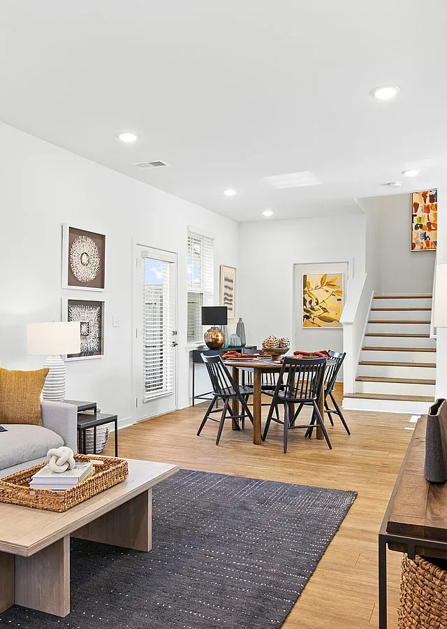 Inviting open-concept living and dining area showcasing modern decor, stylish artwork, and abundant natural light.
