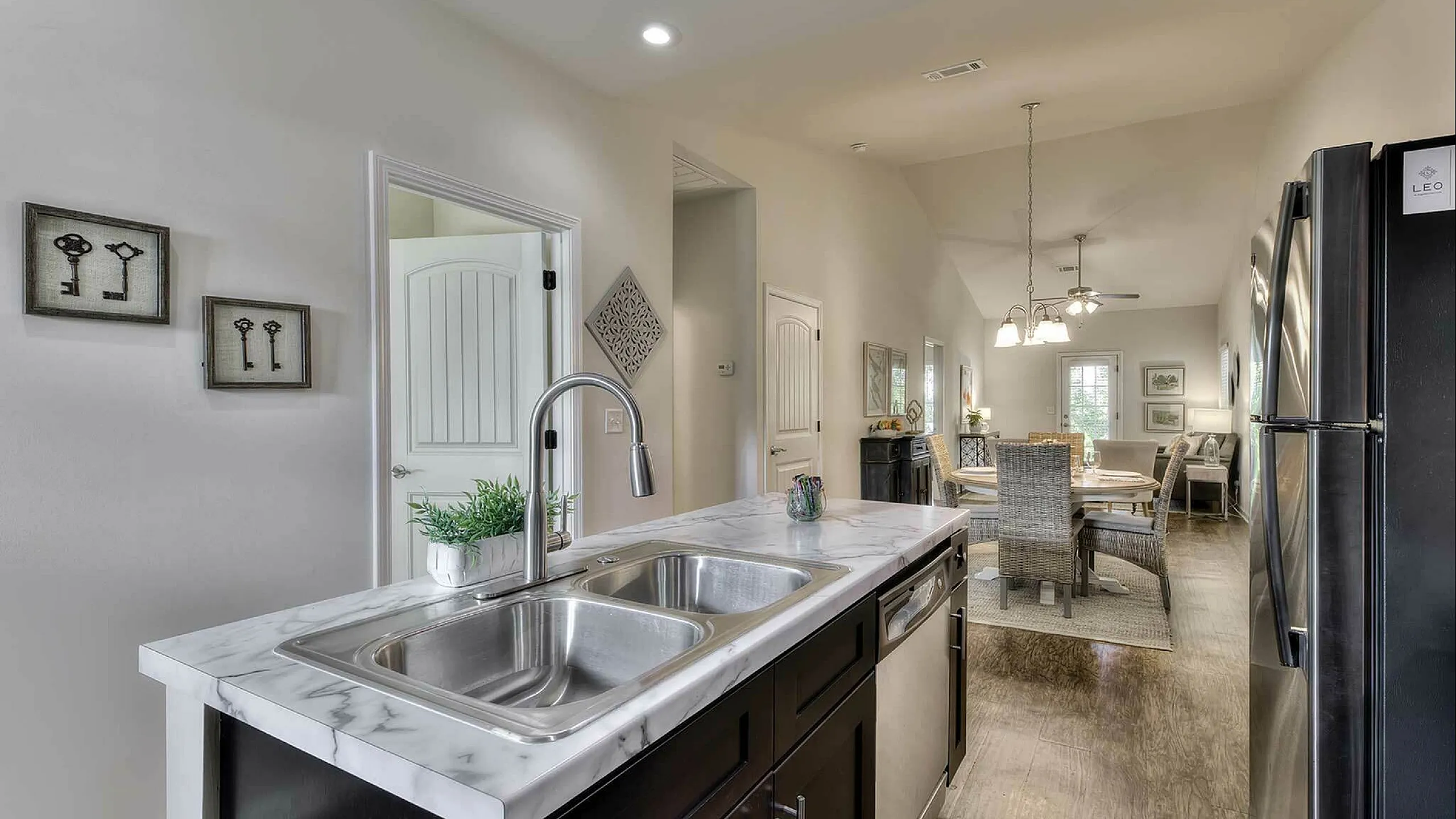 Modern, open-concept kitchen featuring sleek marble countertops and a stylish dining area, perfect for entertaining.