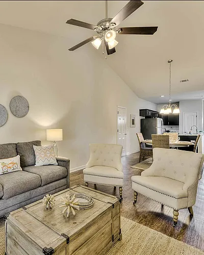 Inviting open-concept living room with elegant furnishings, natural light, and a cozy dining area, perfect for entertaining.