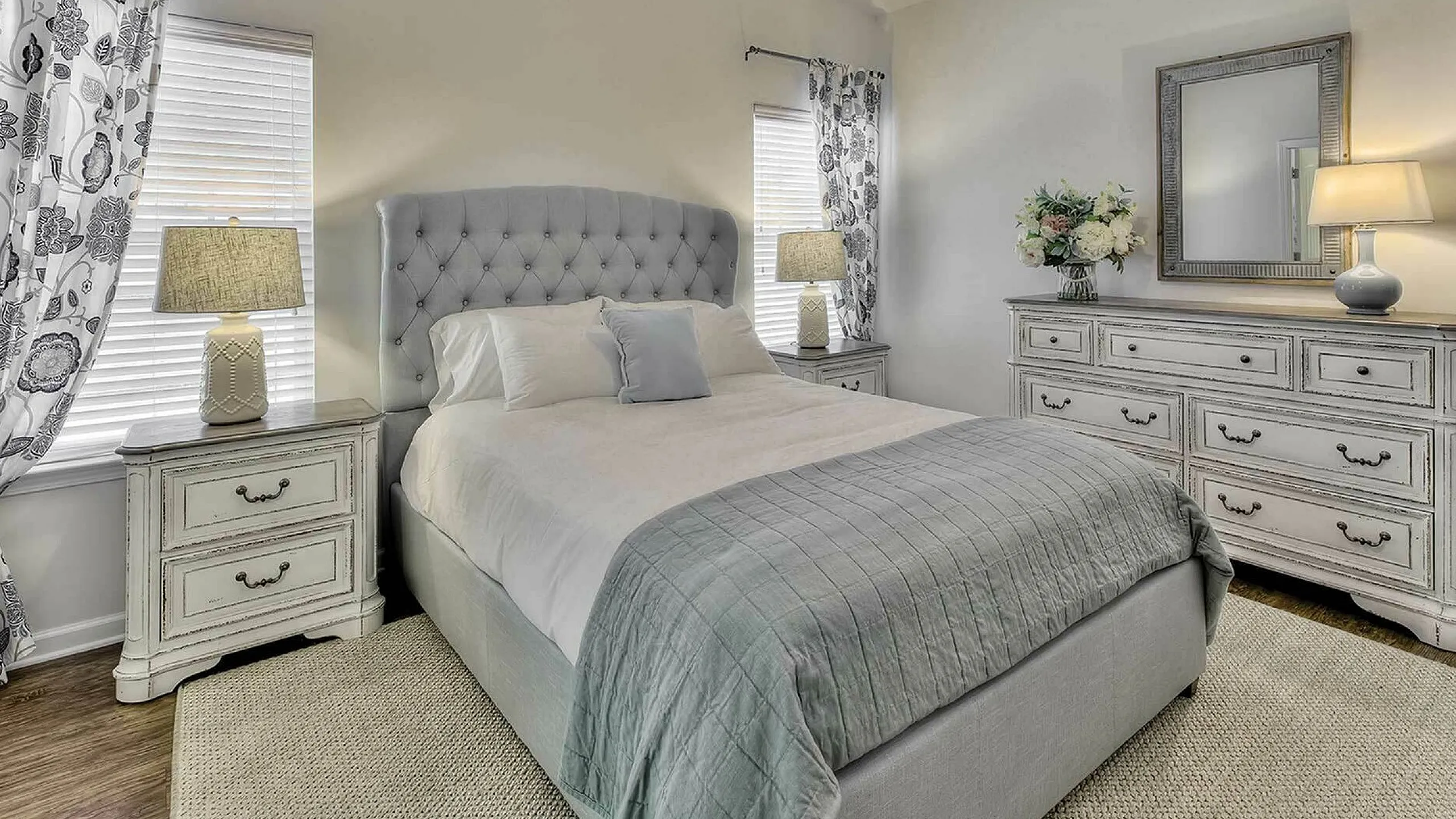 Elegant bedroom with a plush tufted bed, stylish bedside tables, and soft lighting creating a serene atmosphere.