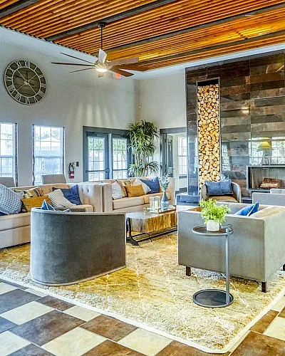 Contemporary lounge area with stylish seating, vibrant decor, and a striking wood-paneled ceiling, perfect for relaxation and social gatherings.