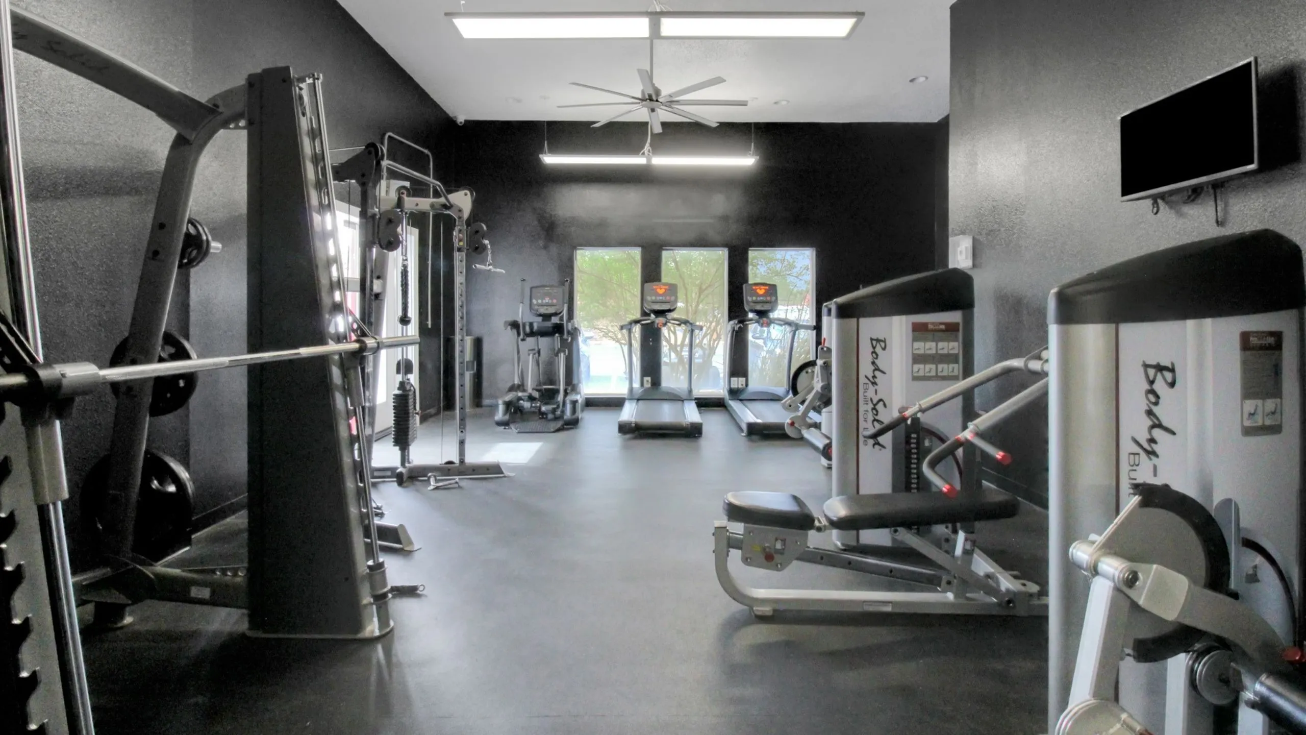 Modern gym with high-tech equipment, featuring treadmills, weight machines, and a sleek design for an ideal workout environment.