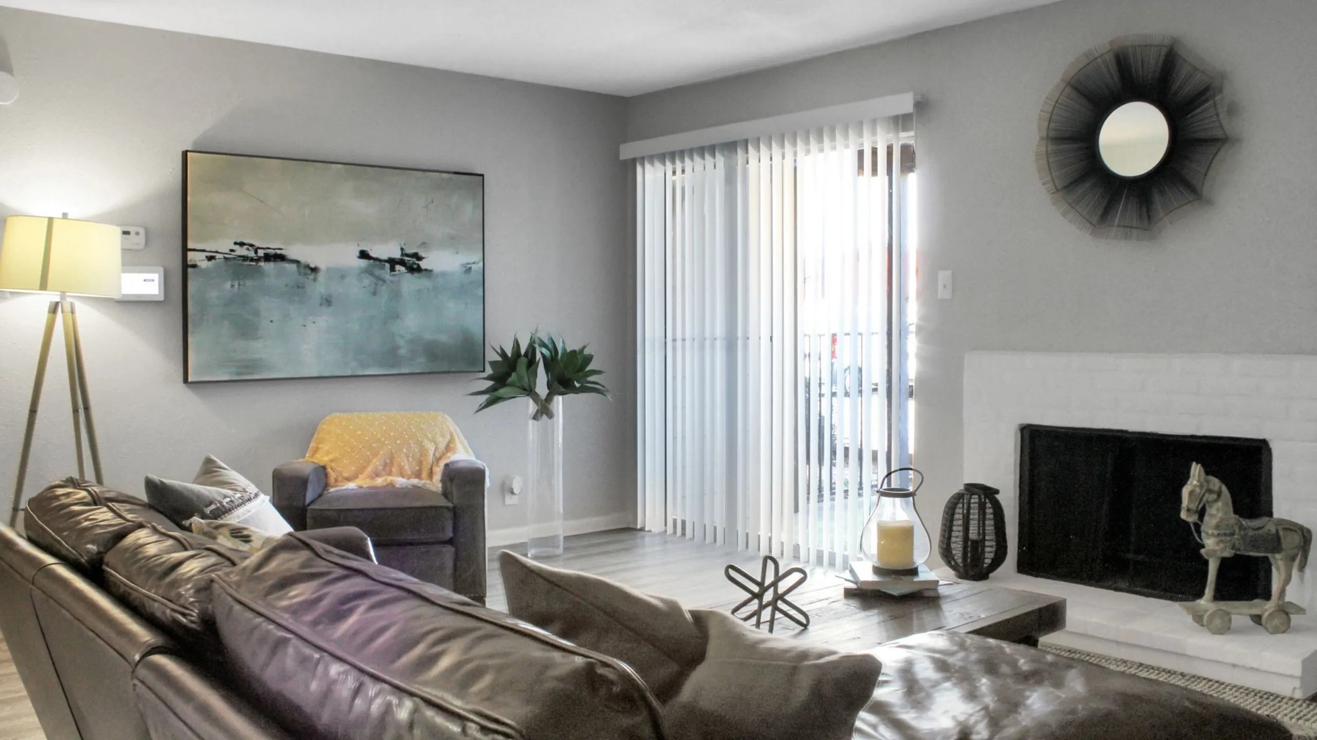 Inviting living room with a cozy ambiance featuring a modern leather sofa, elegant artwork, and a stylish fireplace, perfect for relaxation.