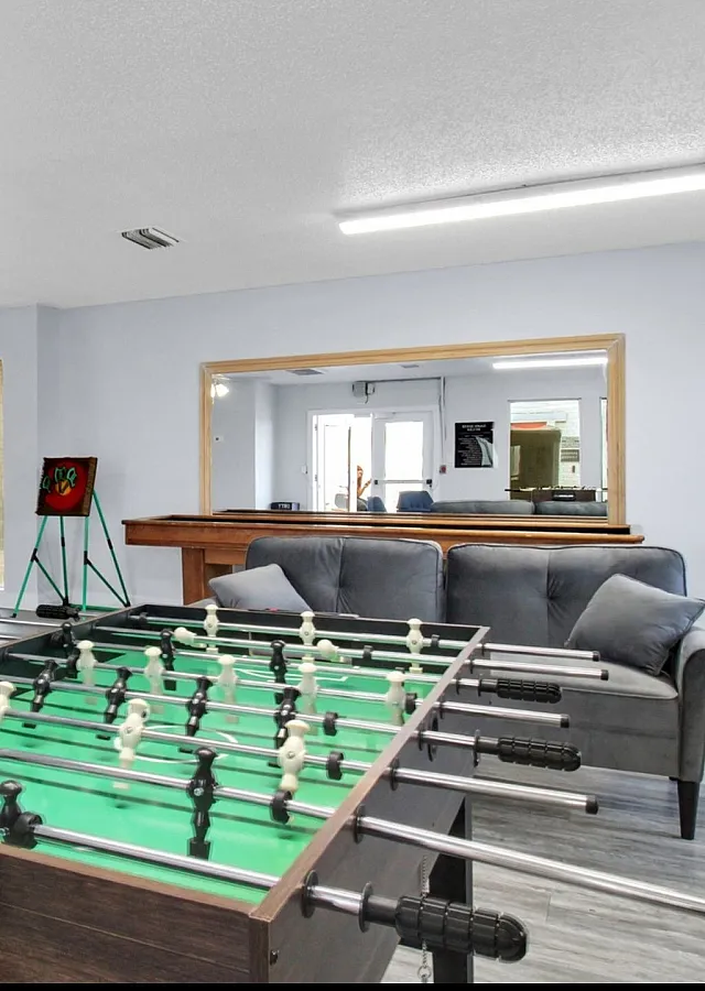 Chic recreational room with a foosball table, cozy seating, and arcade games, perfect for entertaining and relaxation.