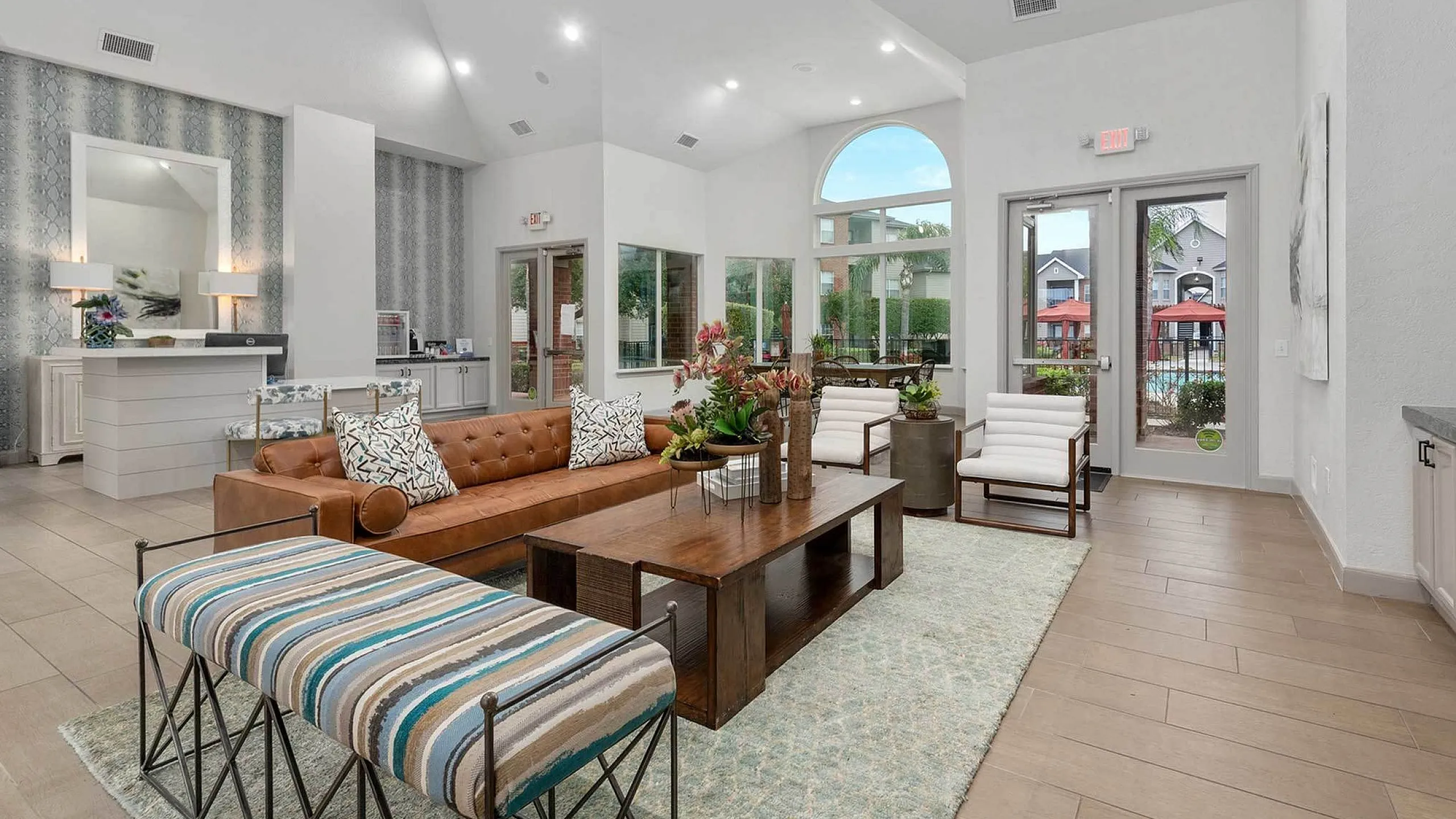 Elegant and inviting living area with modern decor, featuring plush seating and a view of the outdoor pool.