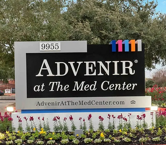 Inviting entrance of Advenir at The Med Center featuring a vibrant landscaped garden and welcoming community signage.