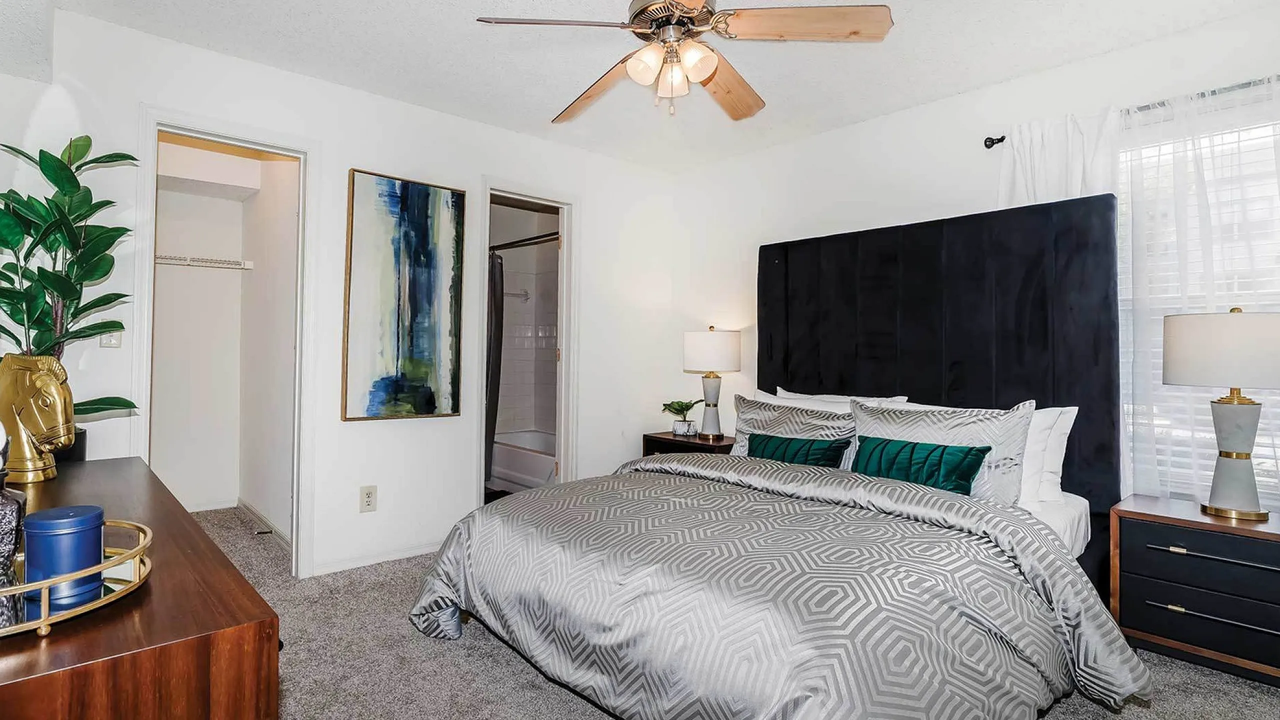 Inviting bedroom with elegant decor, luxurious bedding, and ample natural light, featuring chic furnishings and sophisticated style.