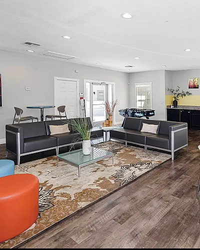 Inviting communal lounge with modern seating, vibrant artwork, and a chic foosball table, perfect for relaxation and socializing.