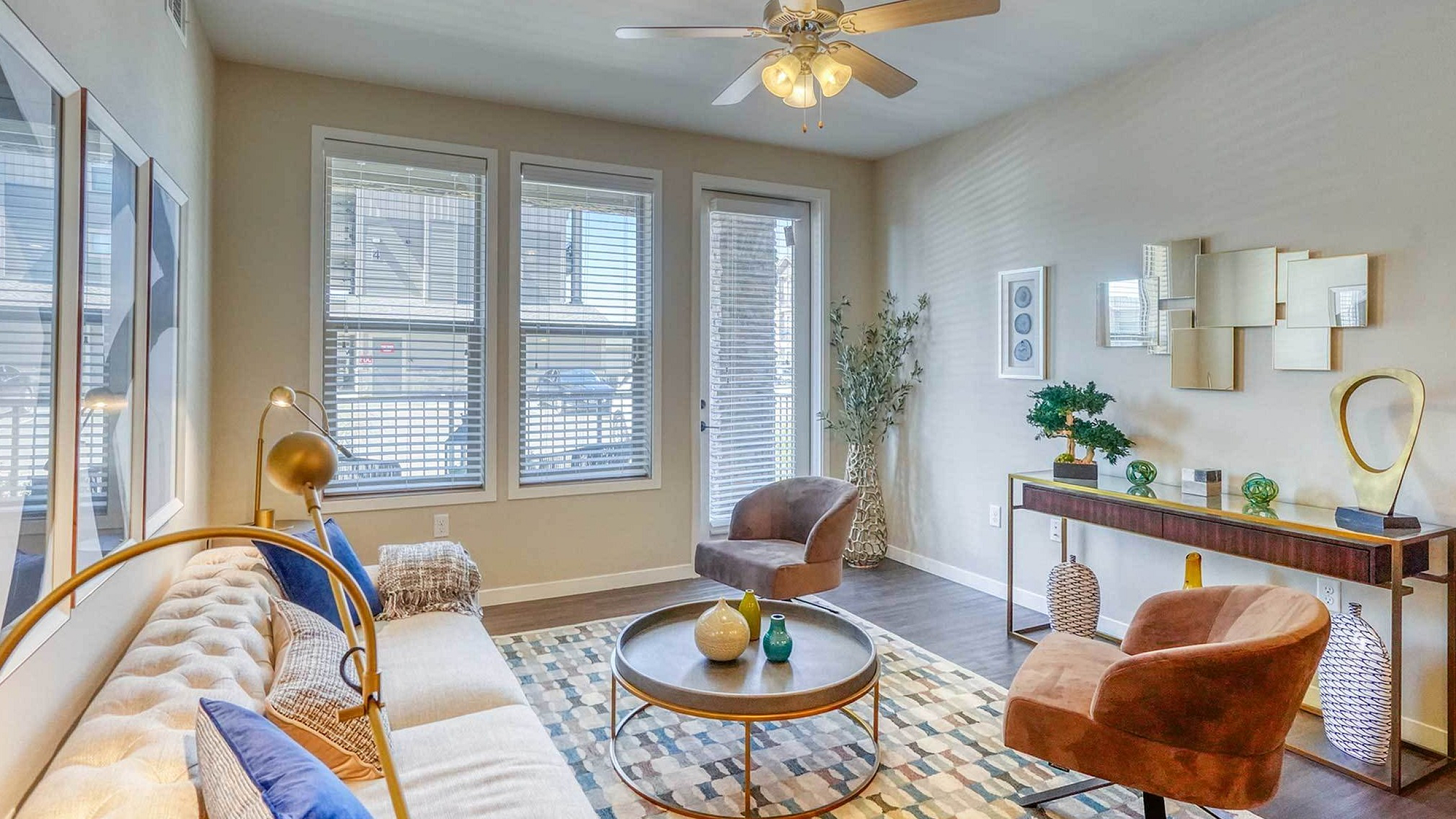 Inviting living room with modern decor, cozy seating, and abundant natural light through large windows.
