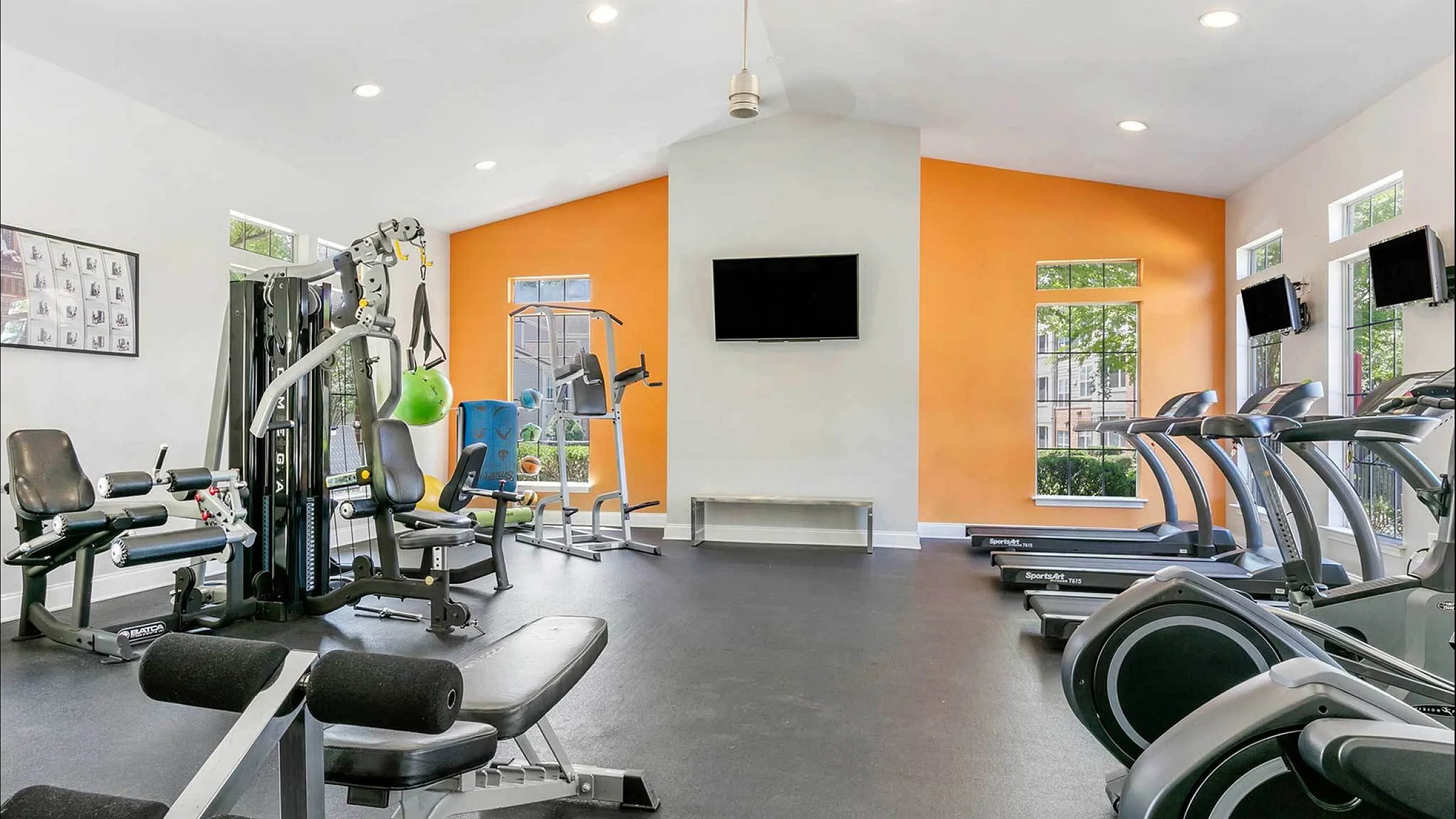 Modern fitness center featuring state-of-the-art equipment, including treadmills and exercise machines, in a bright and inviting space.