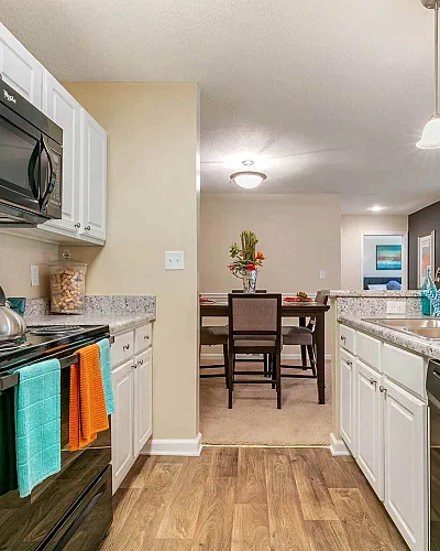 Modern kitchen with sleek appliances and granite countertops leading to a stylish dining area, perfect for entertaining.