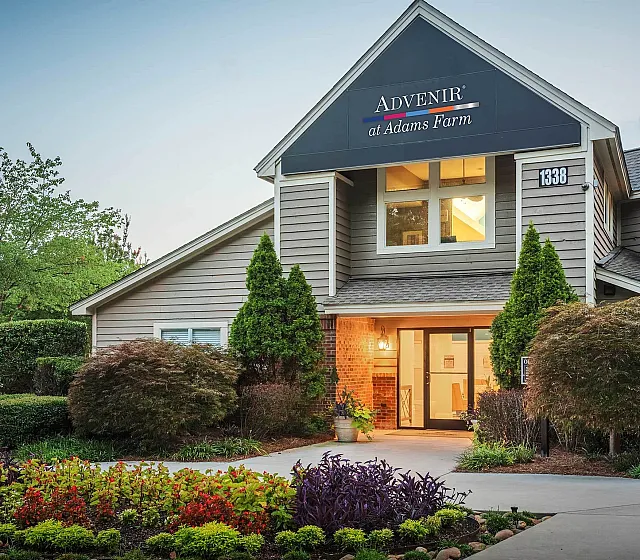 Charming apartment community exterior at Advenir at Adams Farm, showcasing beautifully landscaped gardens and modern architecture.
