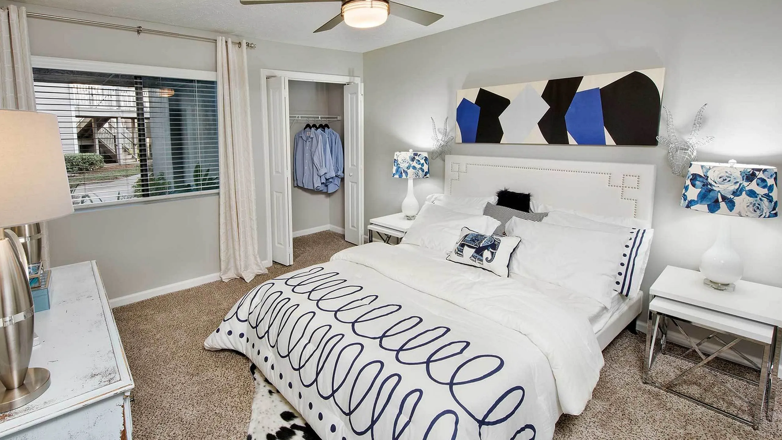 Chic bedroom with modern decor, featuring a stylish bed, elegant art piece, and calming natural light through the window.