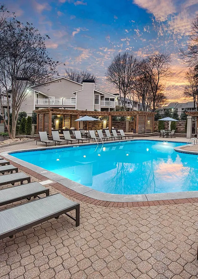 Inviting outdoor pool area with stylish loungers and cozy seating, perfect for relaxation at sunset.