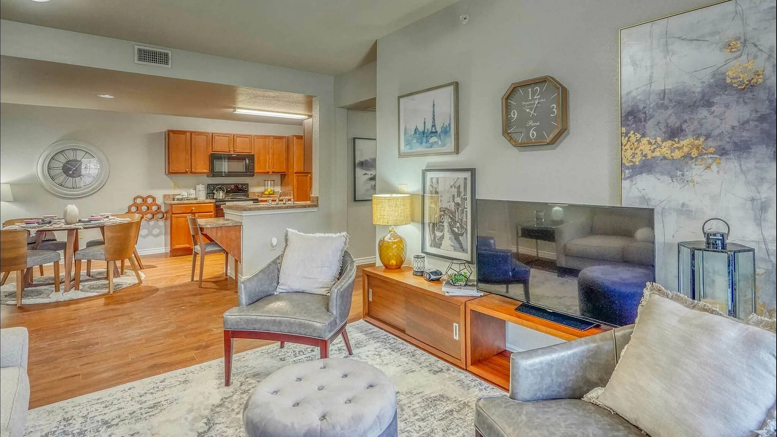 Chic open-plan living room with a cozy seating area, modern decor, and a view into the inviting kitchen and dining space.