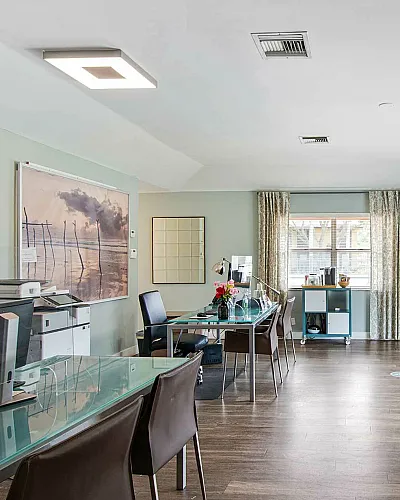 Modern office space with sleek glass desks, comfortable seating, and ambient lighting, perfect for productivity and client meetings.