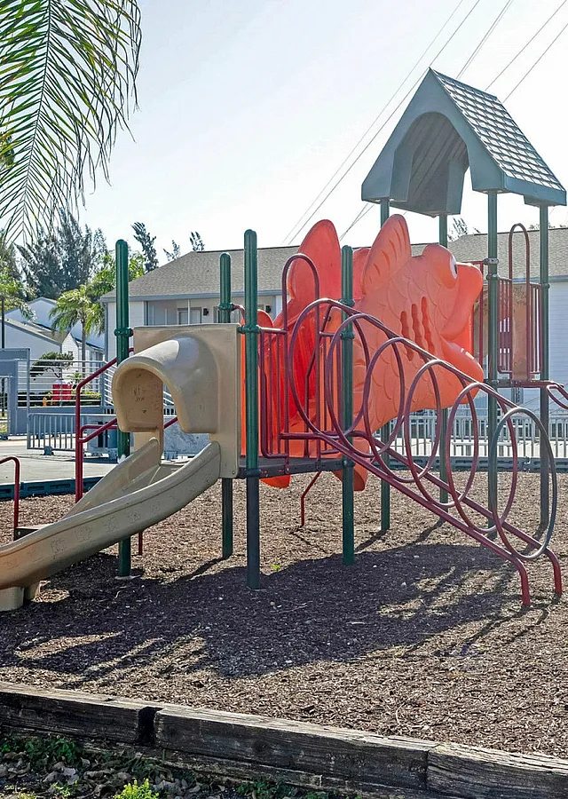 Inviting community playground with vibrant play equipment set in front of modern apartment buildings, perfect for family living.