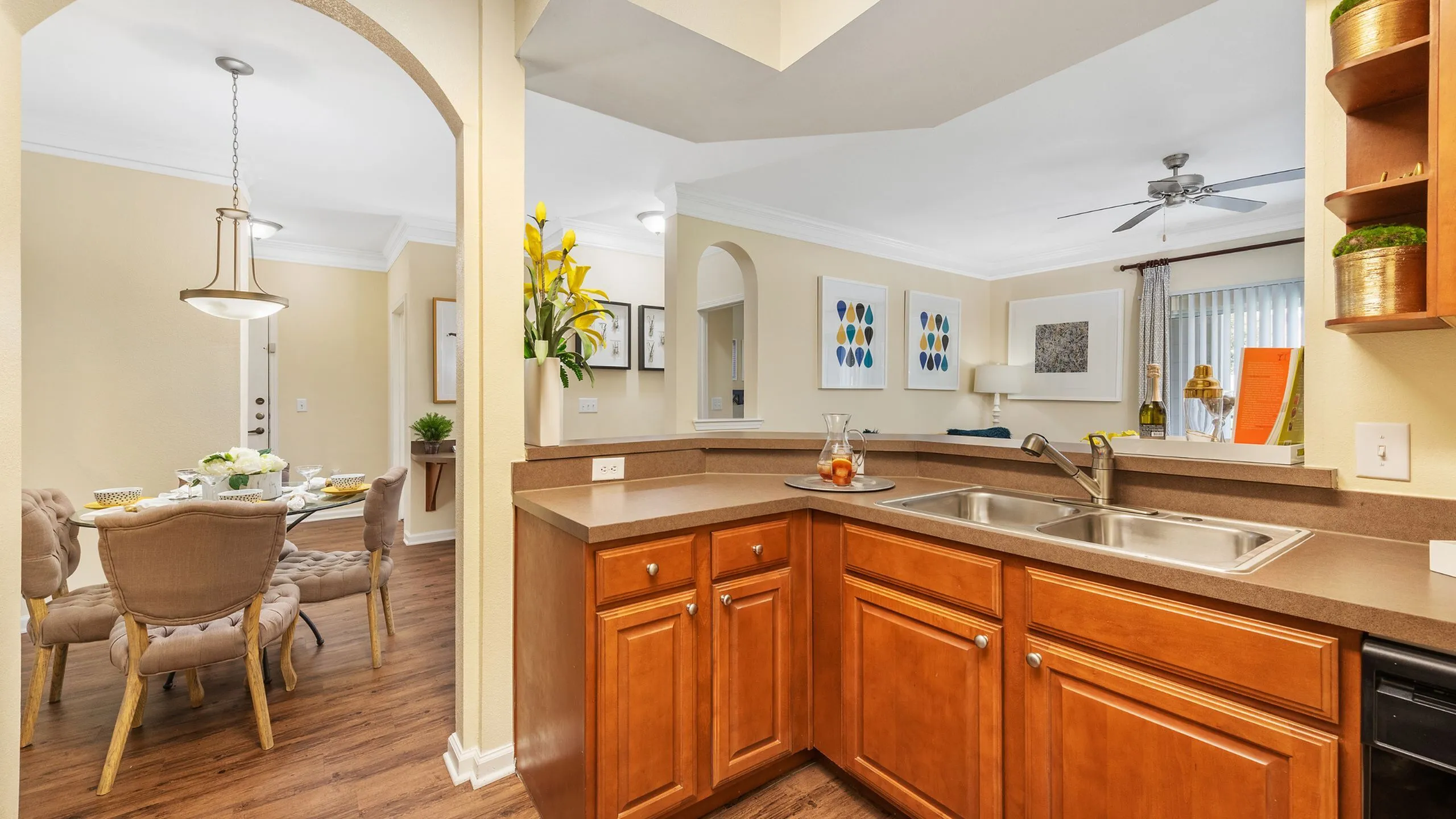 Bright and welcoming open-concept kitchen and dining area featuring elegant wood cabinetry, modern lighting, and a cozy dining setup.