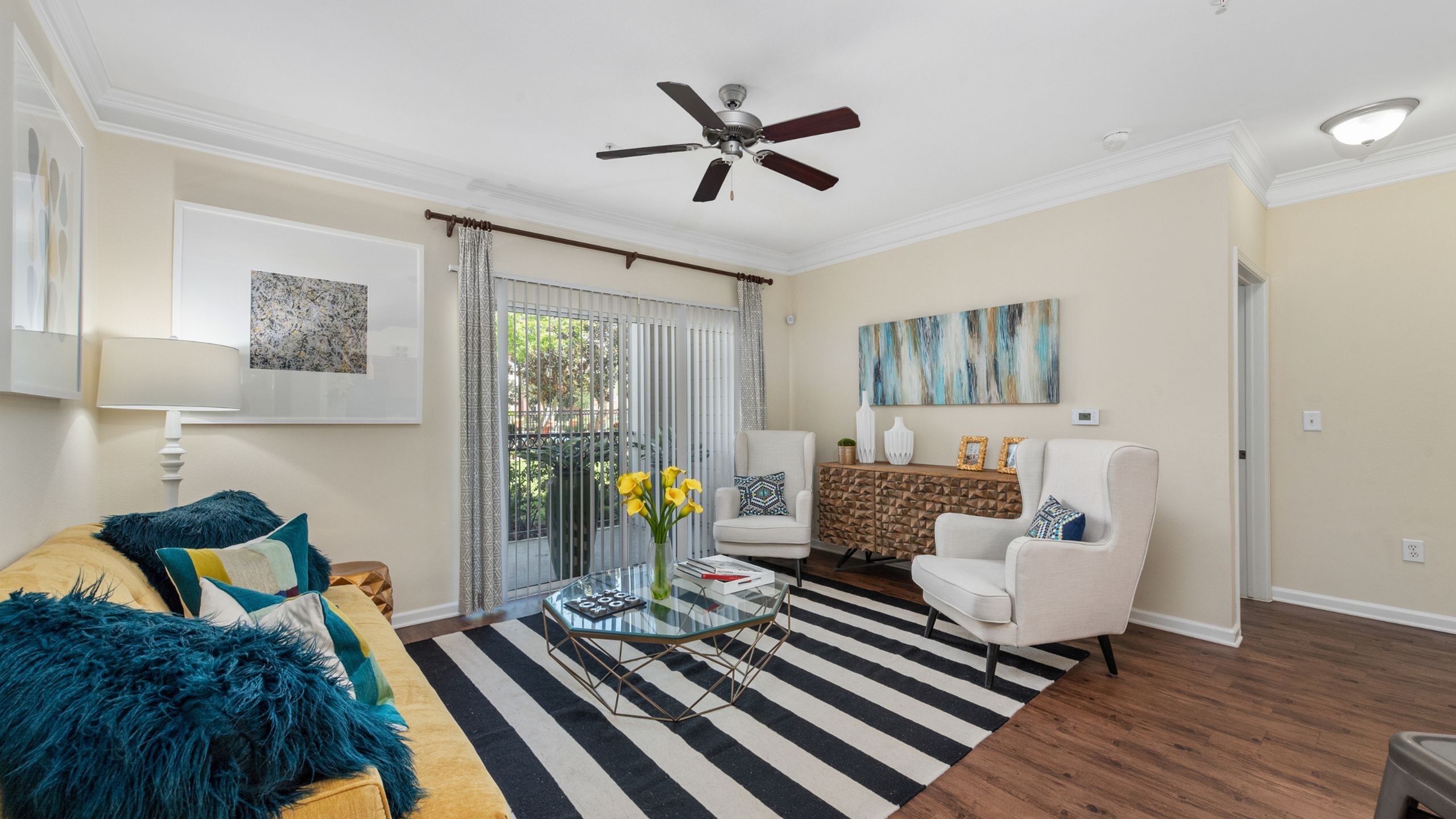 Bright and inviting living room with stylish decor, featuring a cozy yellow sofa, chic armchairs, and elegant wall art, perfectly complementing the modern ambiance.