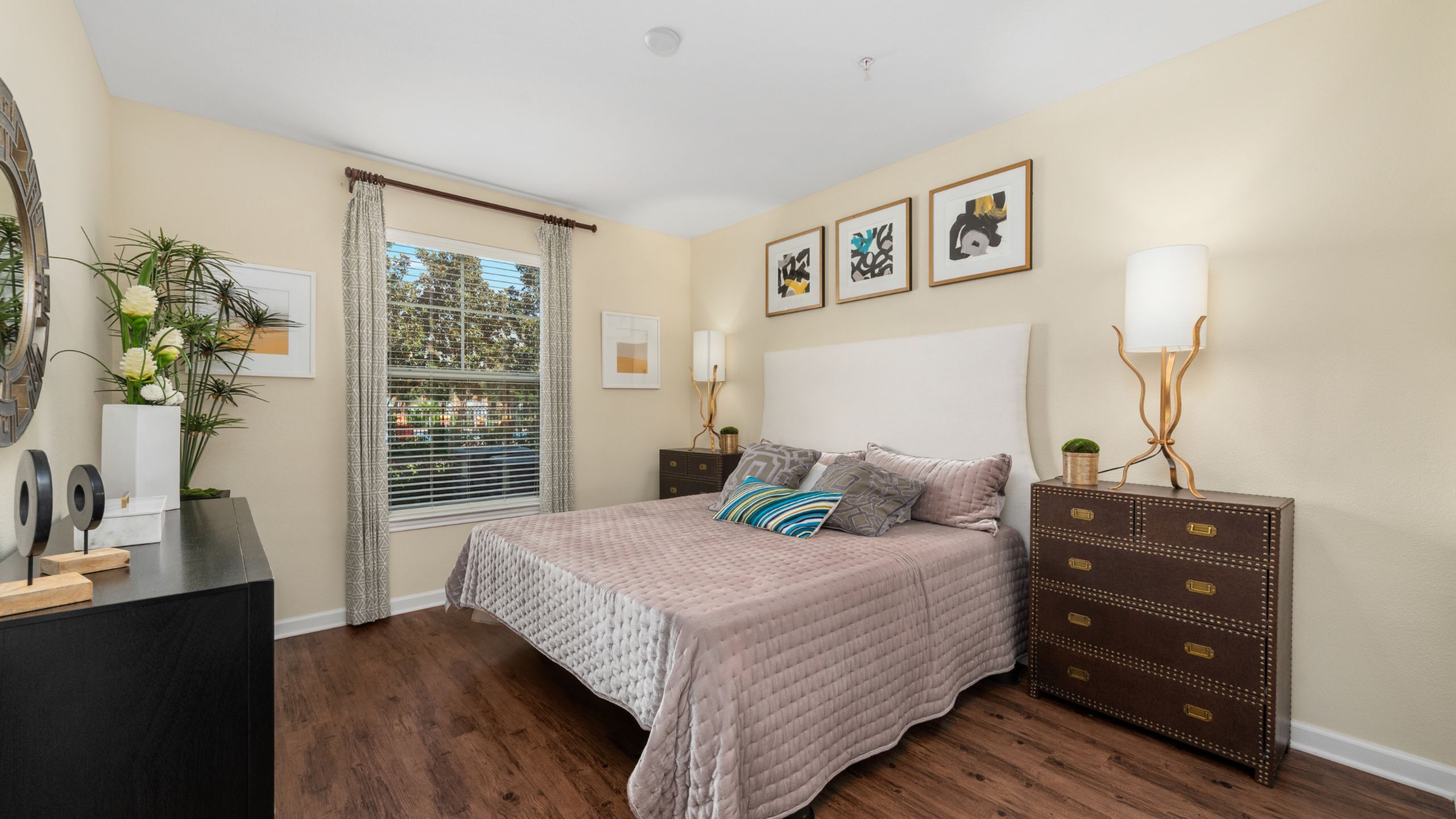 Elegant bedroom featuring a cozy queen-sized bed with plush bedding, chic decor, and a large window inviting natural light.