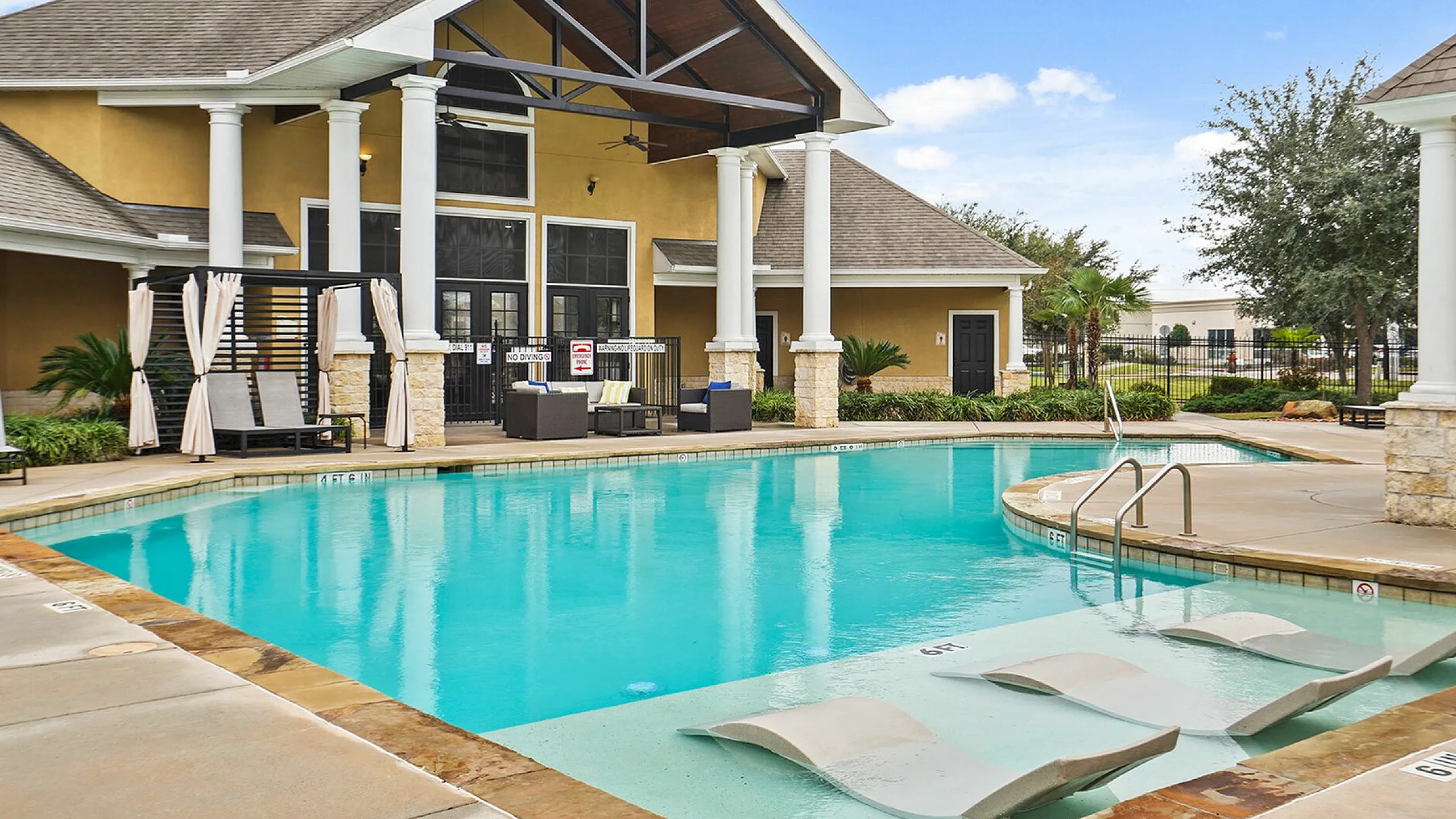 Inviting apartment complex pool area with elegant cabanas and modern loungers, perfect for relaxation and social gatherings.