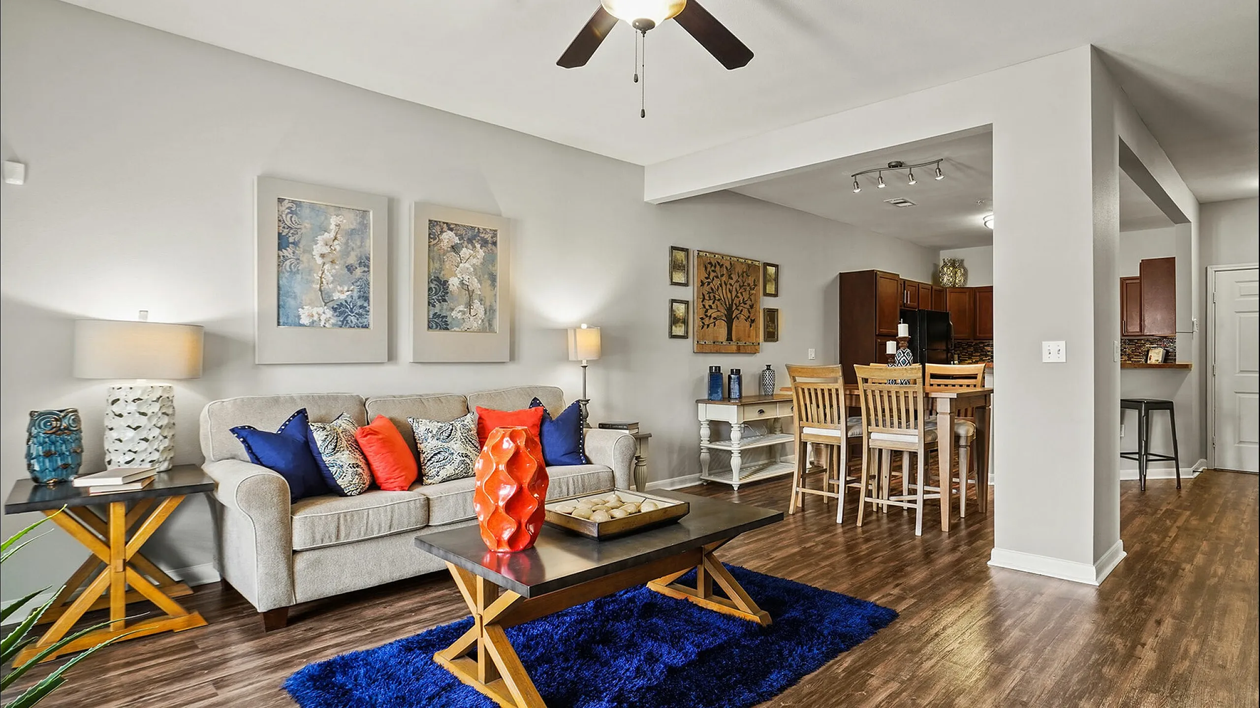 Inviting open-concept living space featuring stylish decor, modern kitchen, and cozy seating area with vibrant accents.