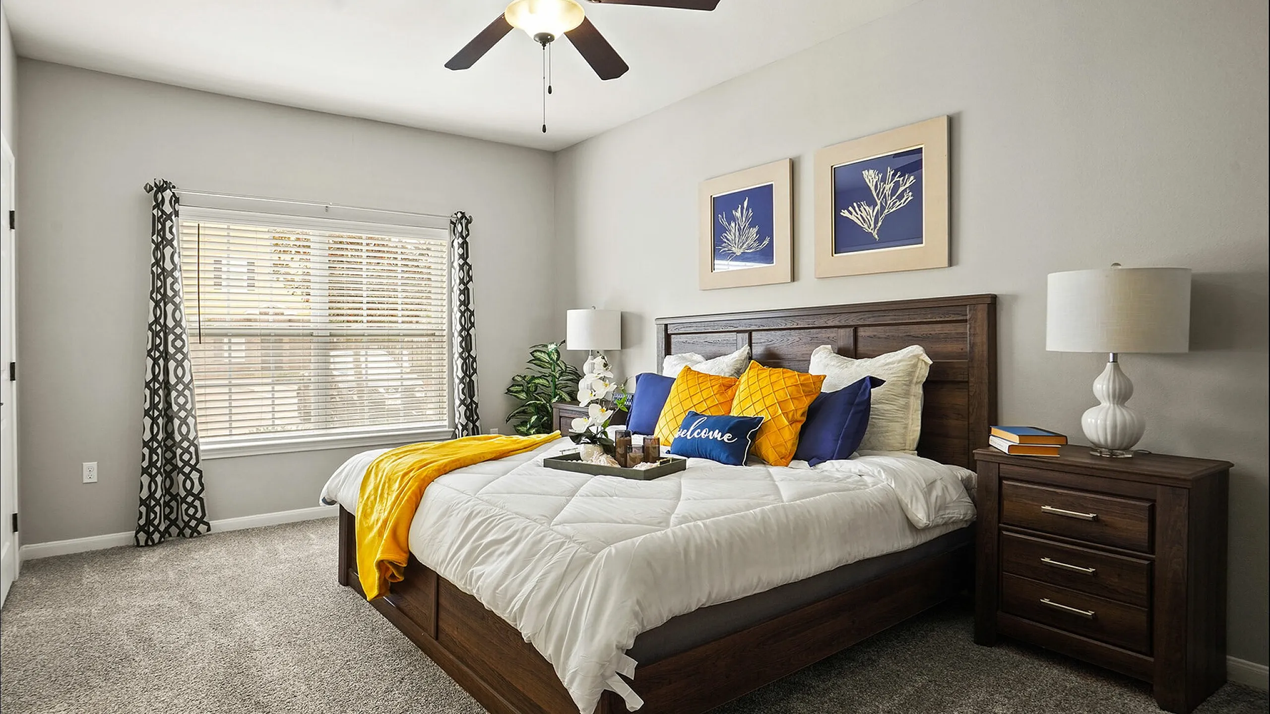 Elegant bedroom with a cozy feel, featuring a large wooden bed adorned with vibrant throw pillows and modern bedside lamps.