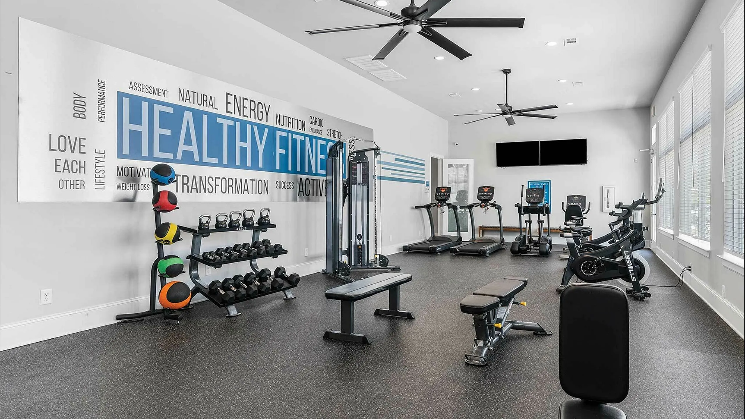 Modern fitness center with state-of-the-art equipment and motivational decor, featuring cardio machines and strength-training gear in a bright, airy setting.