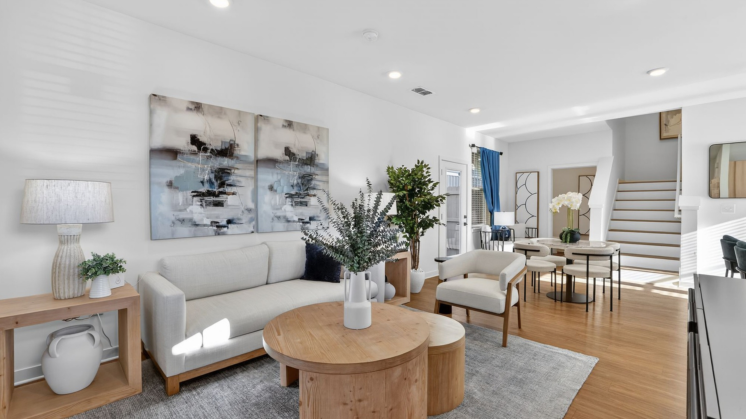 Chic and contemporary living room showcasing elegant d&eacute;cor, plush seating, modern artwork, and natural lighting.