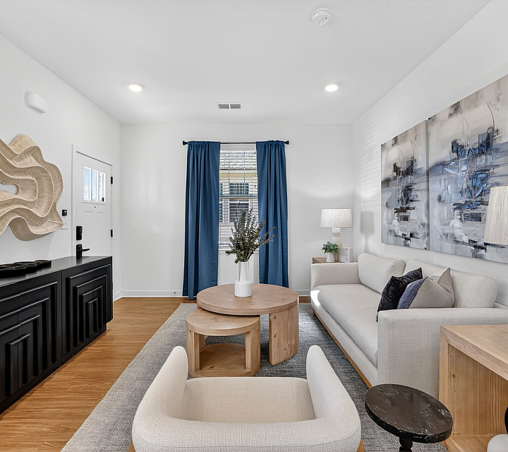 Stylish living room featuring modern decor, cozy white sofa, elegant wood furniture, and bold blue curtains.