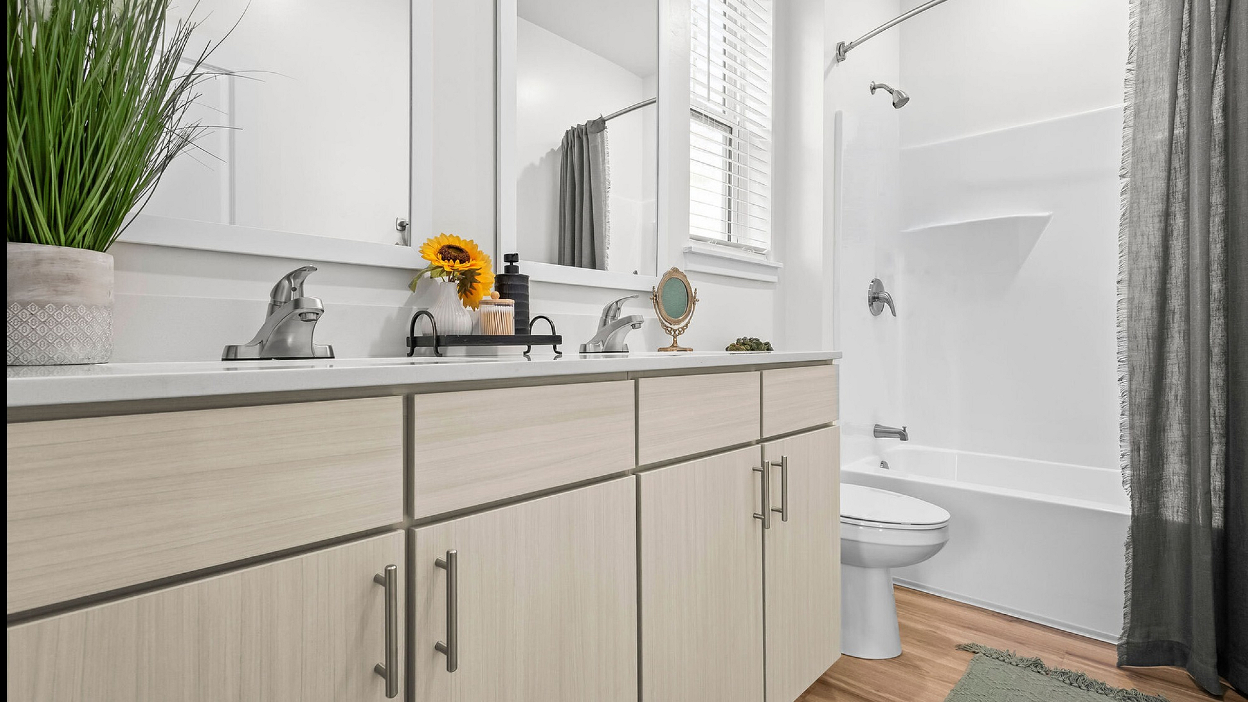 Chic bathroom design featuring a sleek vanity with storage, elegant fixtures, a vibrant sunflower accent, and a modern shower curtain.