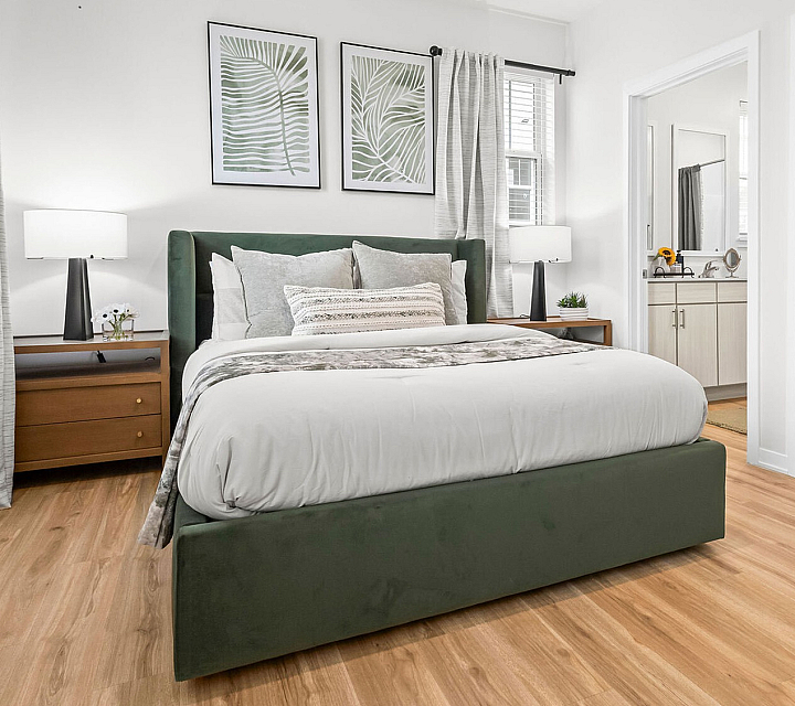Bright and inviting bedroom with stylish decor, featuring a plush bed, modern side tables, and large windows for natural light.