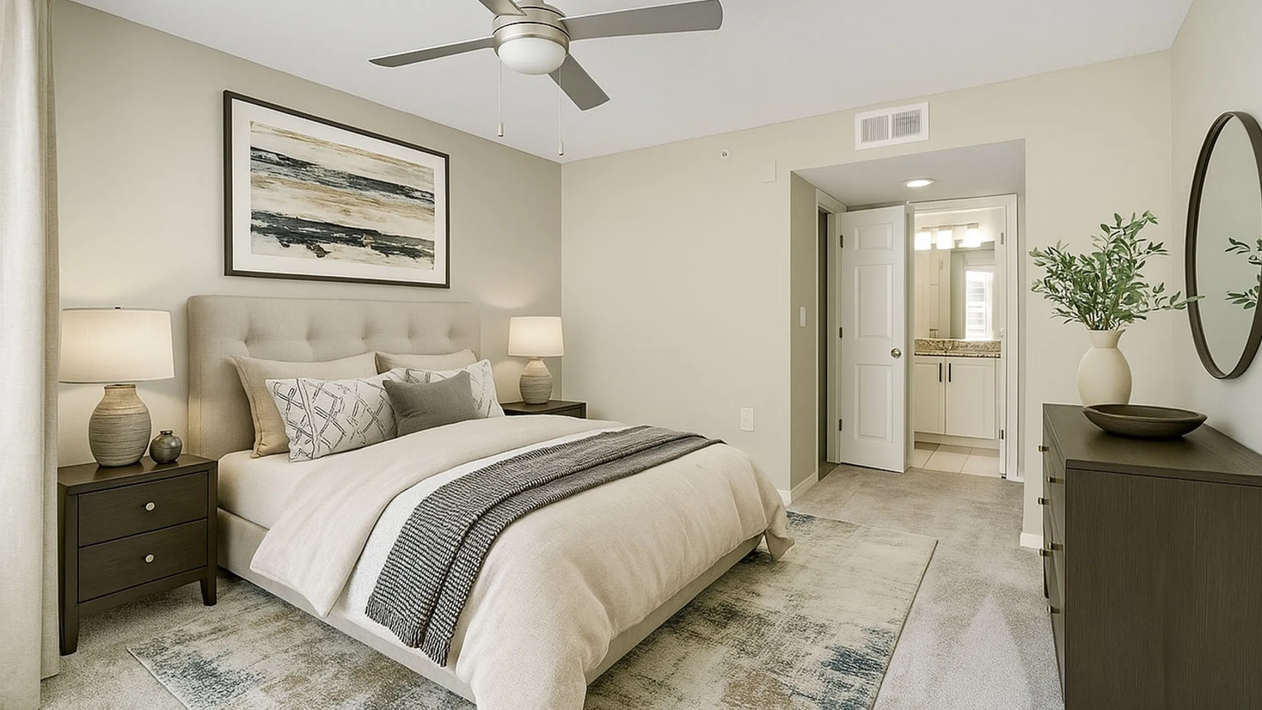 Elegant bedroom with a plush bed, stylish decor, and en-suite bathroom, featuring a calming color palette and modern ceiling fan.