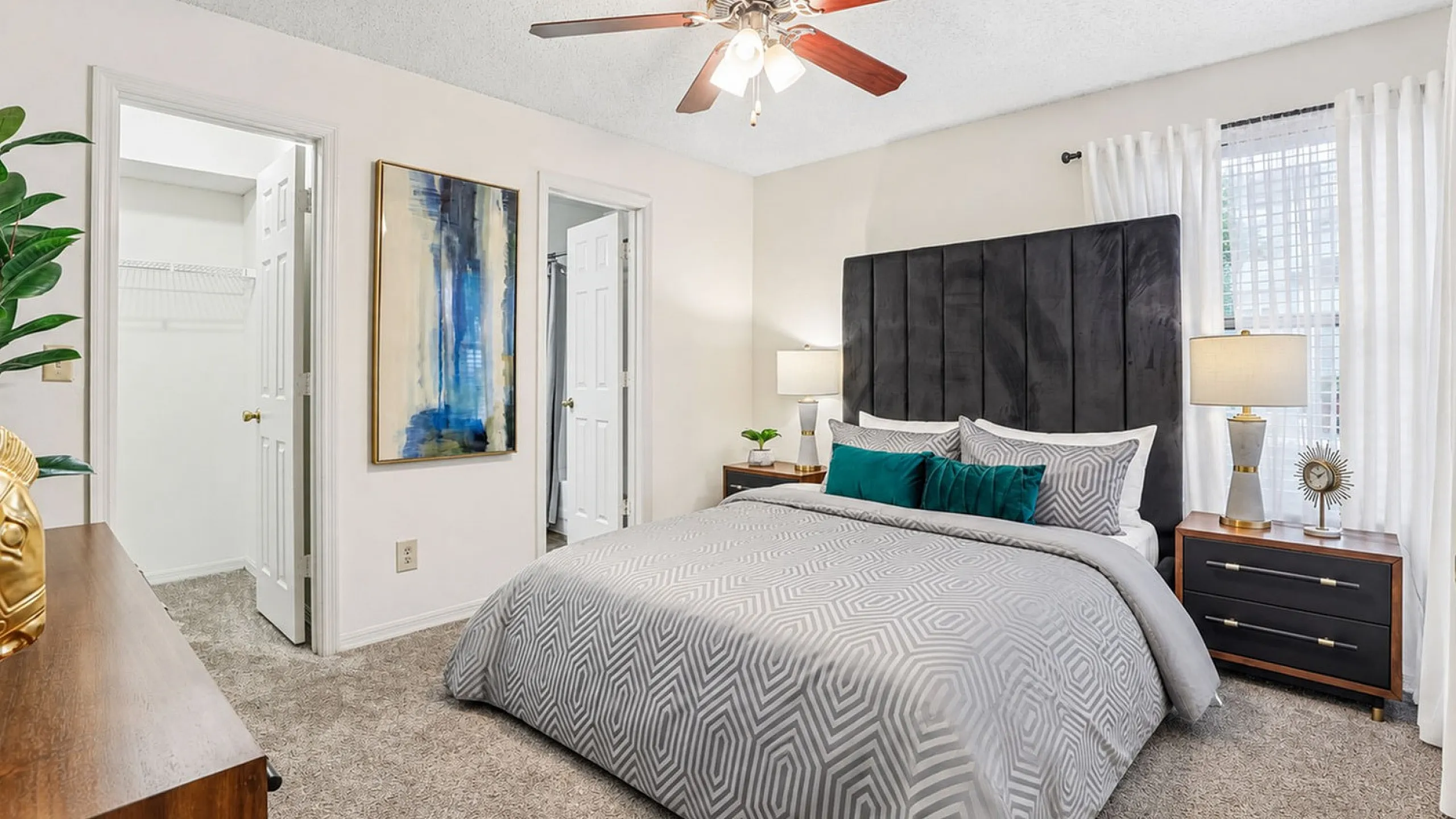 Elegant bedroom featuring plush bedding, modern artwork, and warm lighting, creating a cozy and inviting atmosphere.