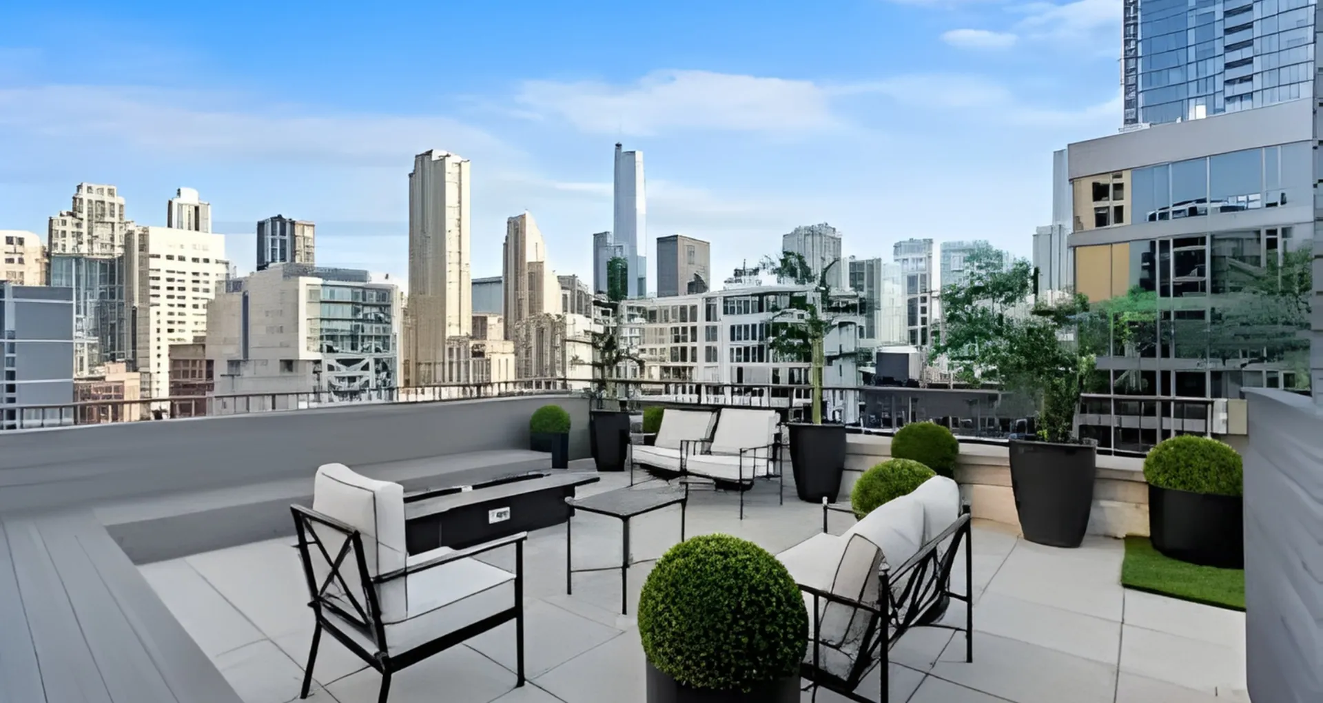 Chic rooftop terrace with comfortable seating, lush greenery, and stunning city skyline views.