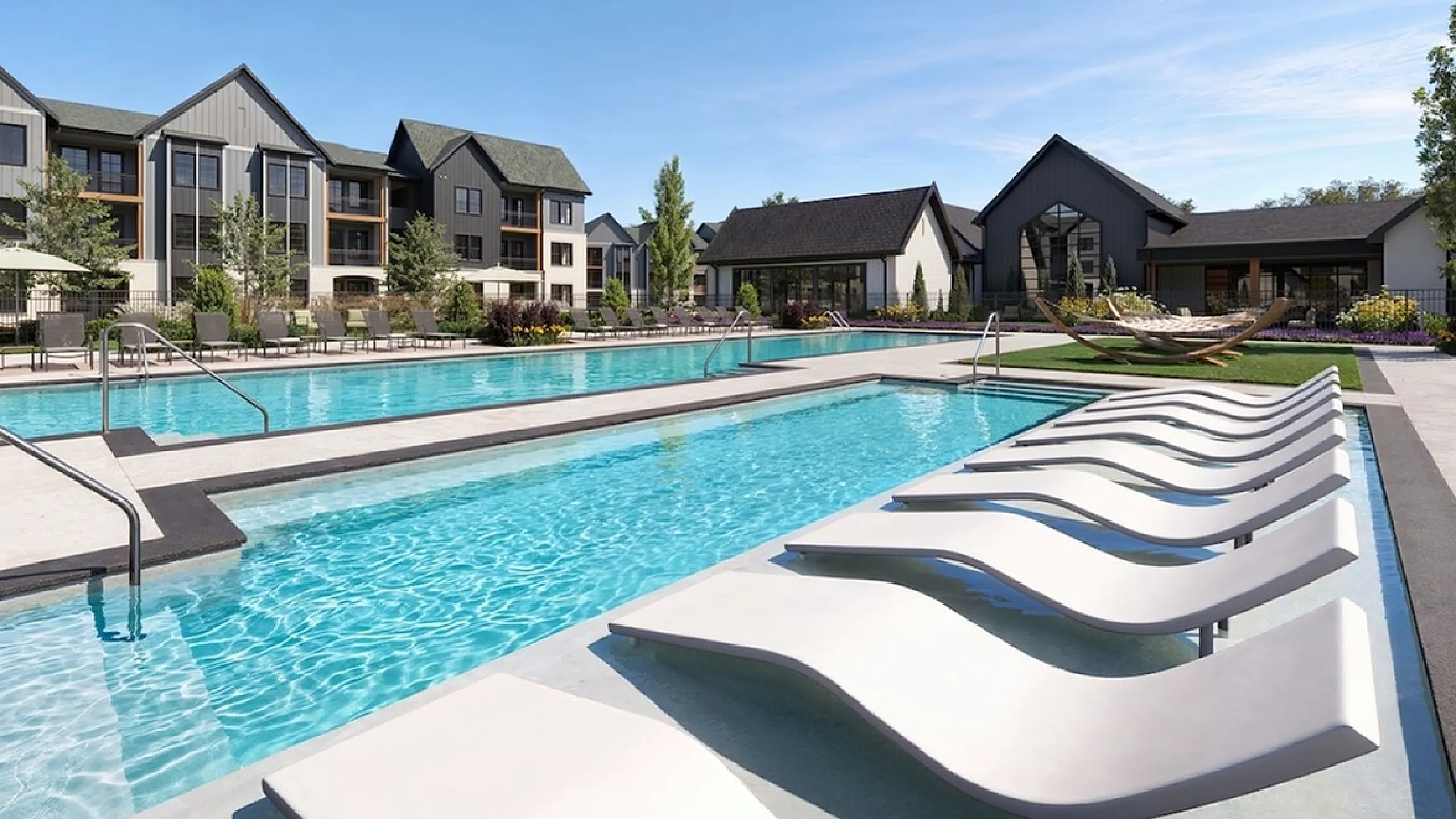 Inviting outdoor pool with stylish lounge chairs and modern apartment buildings in the background.