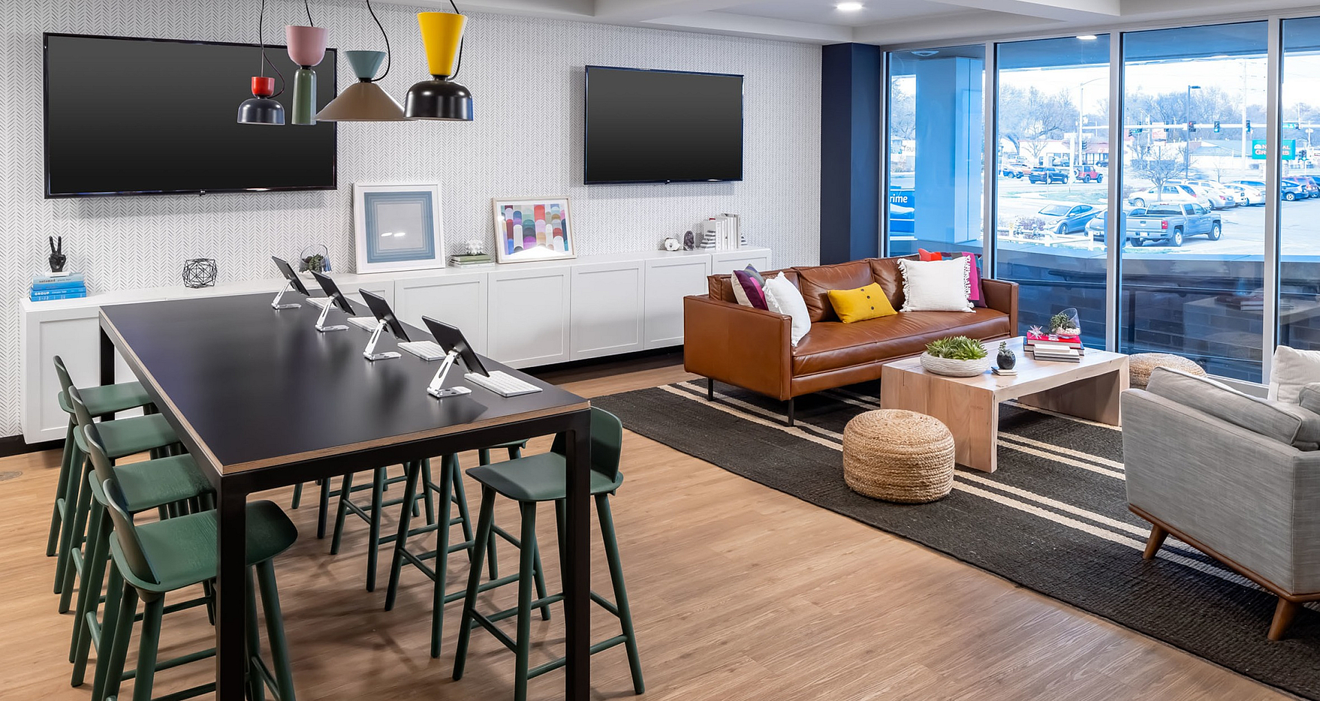 Modern lounge area featuring a stylish workspace, leather sofa, and floor-to-ceiling windows.