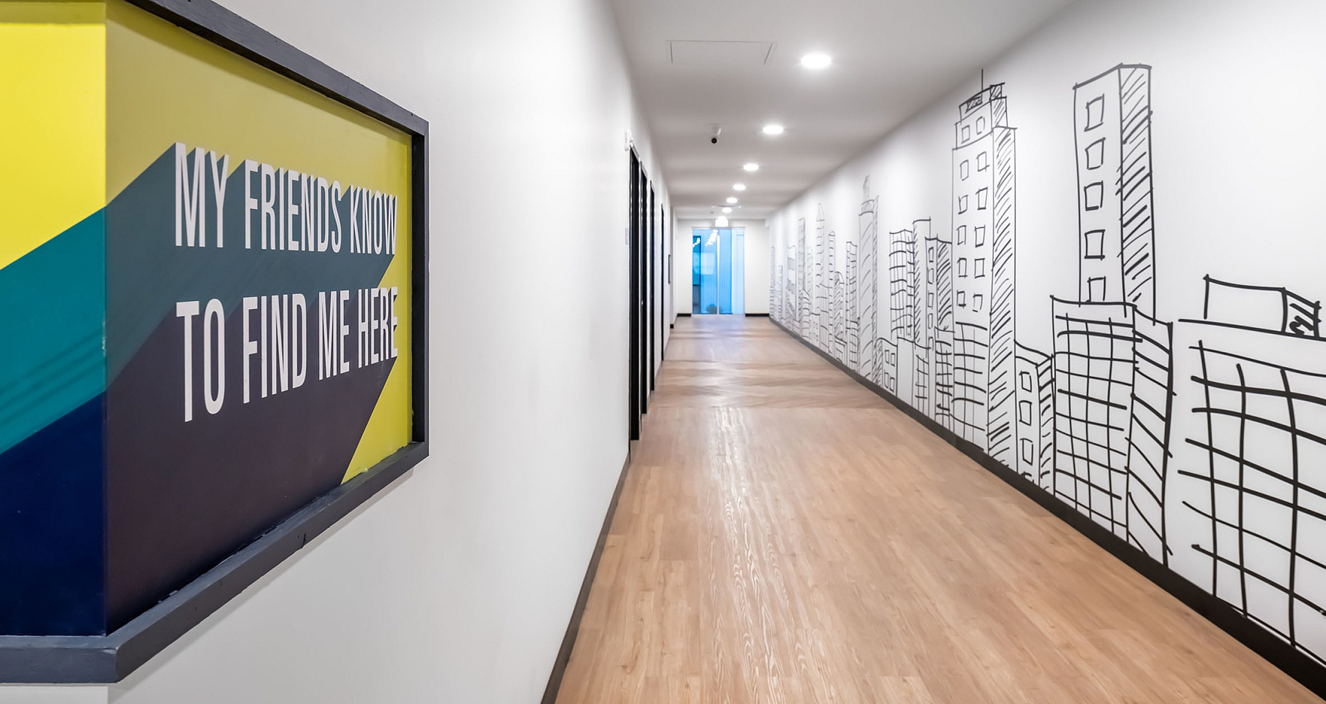 Stylish hallway with vibrant signage and urban-themed wall art showcasing a dynamic cityscape.