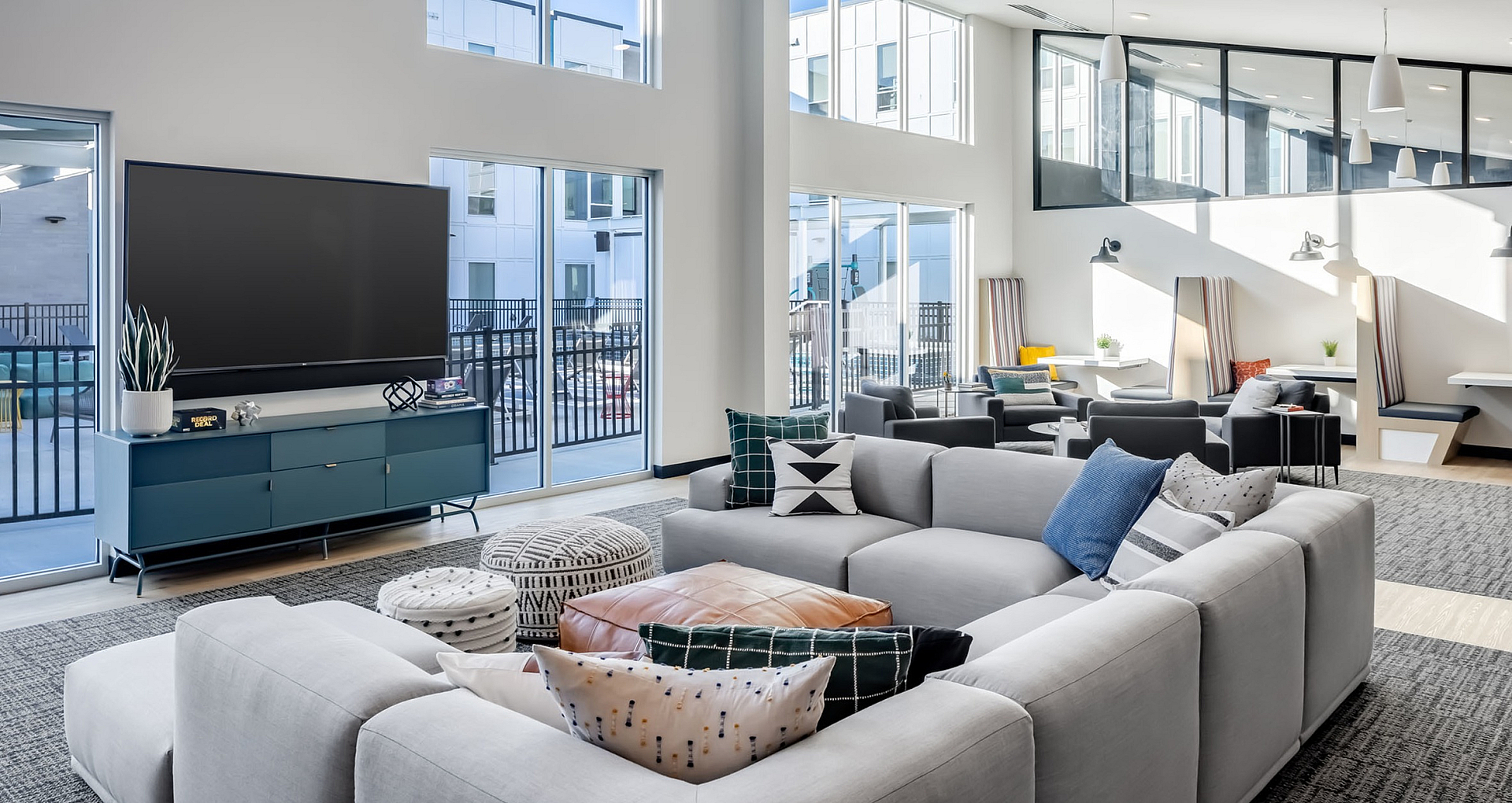 Spacious open-concept living room with large windows, stylish furniture, and modern decor.