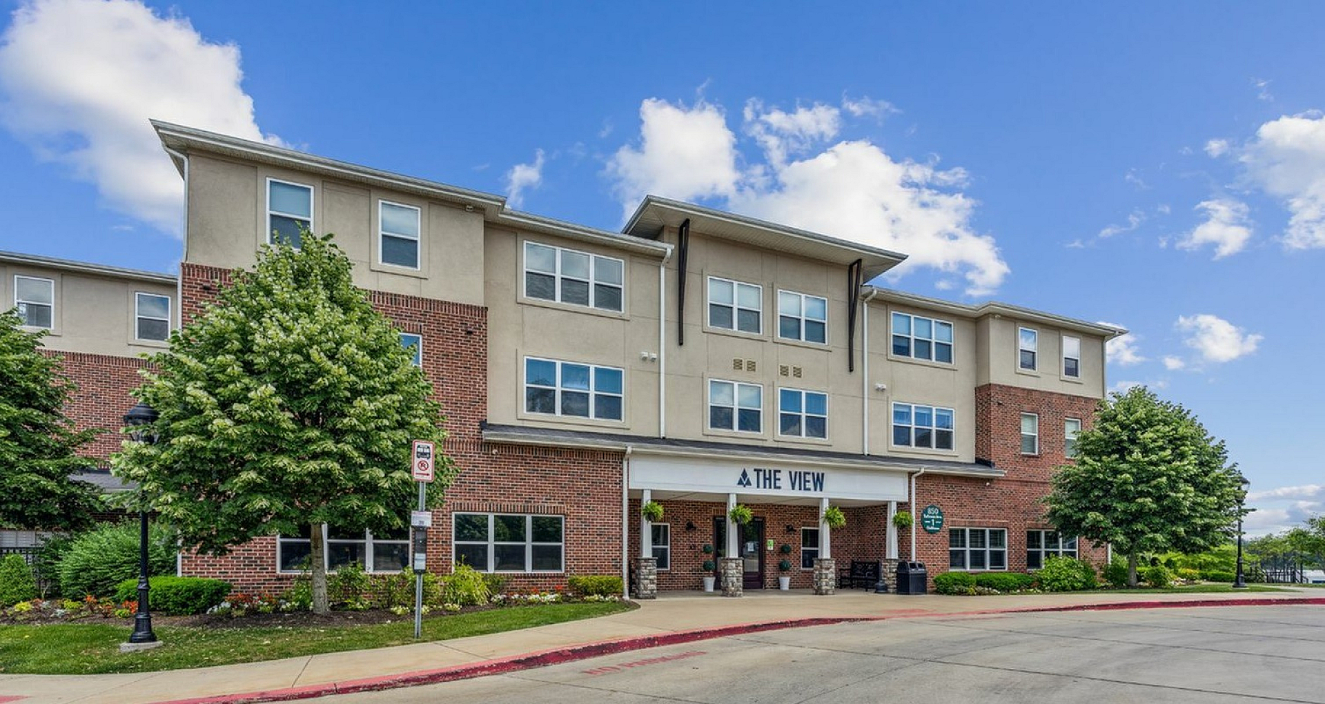 Inviting apartment complex with manicured landscaping and a bright exterior, showcasing modern urban living at The View.