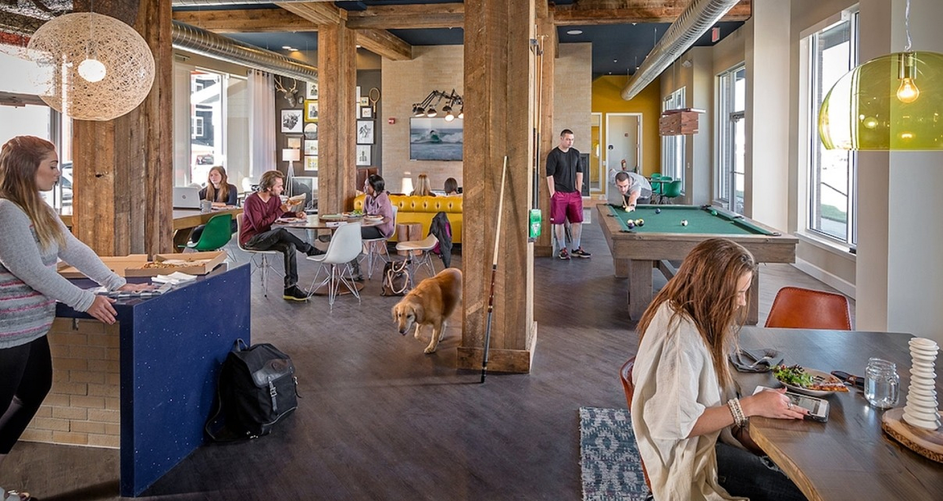 Vibrant and spacious community lounge featuring rustic wood beams, a pool table, cozy seating areas, and modern decor ideal for social gatherings.