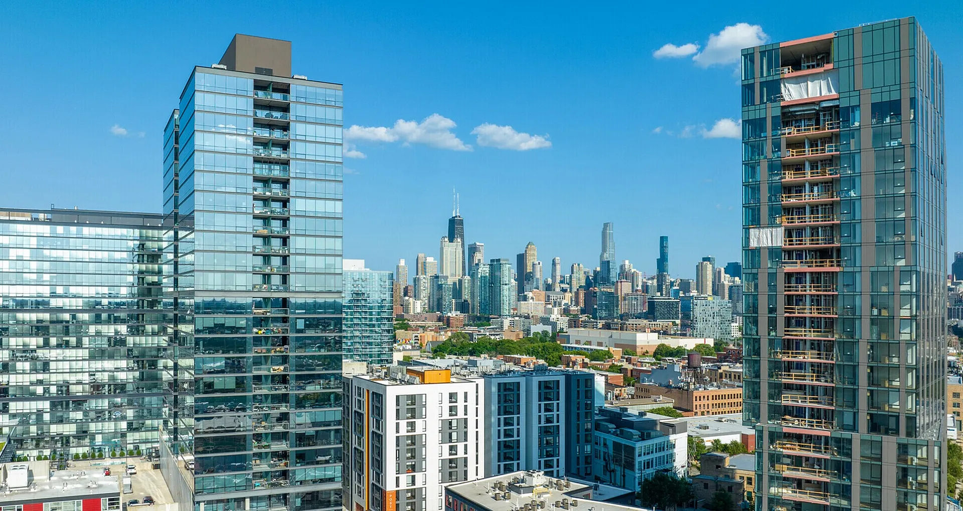 Stunning urban skyline view showcasing contemporary high-rise apartments with glass exteriors in a vibrant city setting.